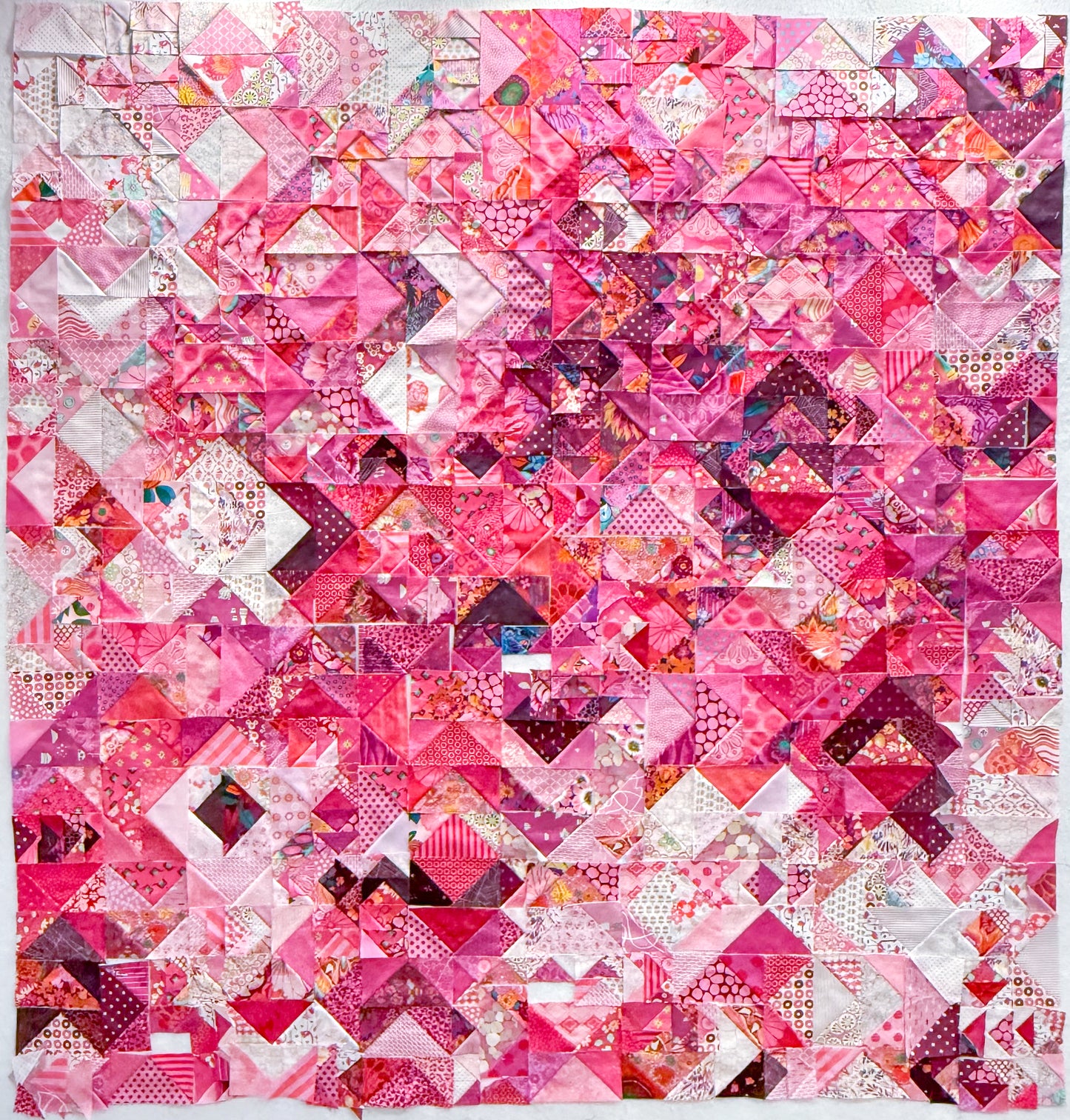 The Misunderstood Quilt by Creative Spark blends color, value, and precision in a vibrant patchwork of pinks with white, purple, and red accents, featuring expertly pieced geometric squares and triangles.