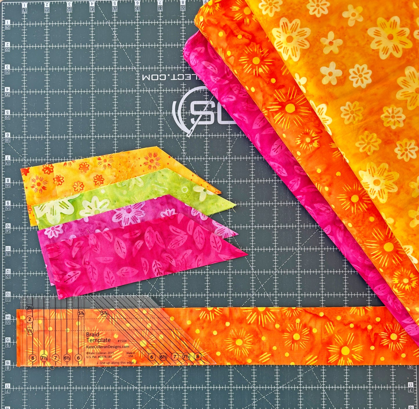 Four colorful fabric pieces from Creative Spark’s Patchwork Braids 101 Basics rest on a cutting mat with measurement lines and a clear quilting ruler—ideal for trying new quilt patterns or making patchwork braids.