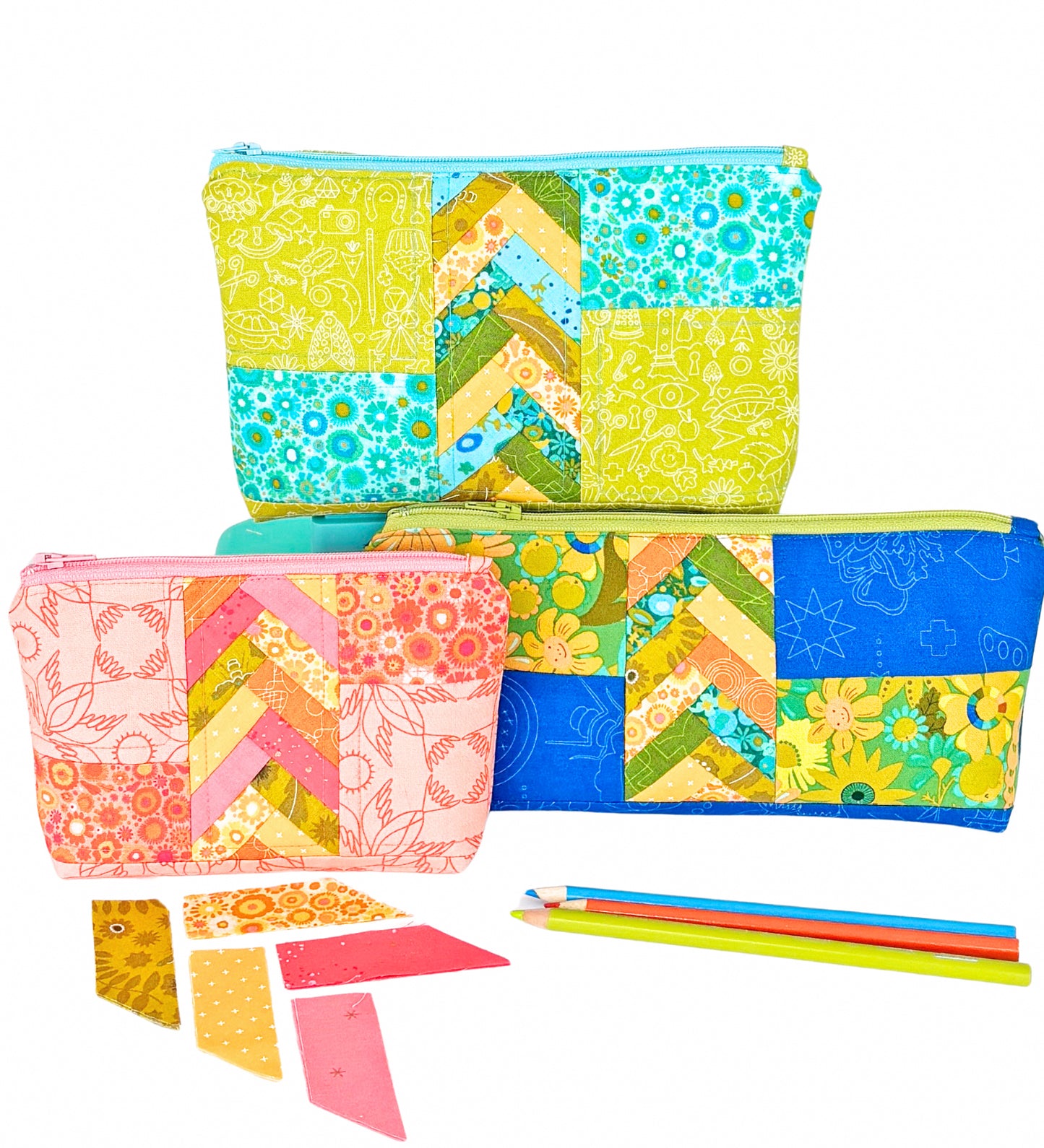 Three colorful Patchwork Braids 101 Basics quilted zipper pouches by Creative Spark, featuring chevron and vibrant patchwork patterns in blue, green, yellow, and pink, are shown with colored pencils and fabric pieces on a white background.