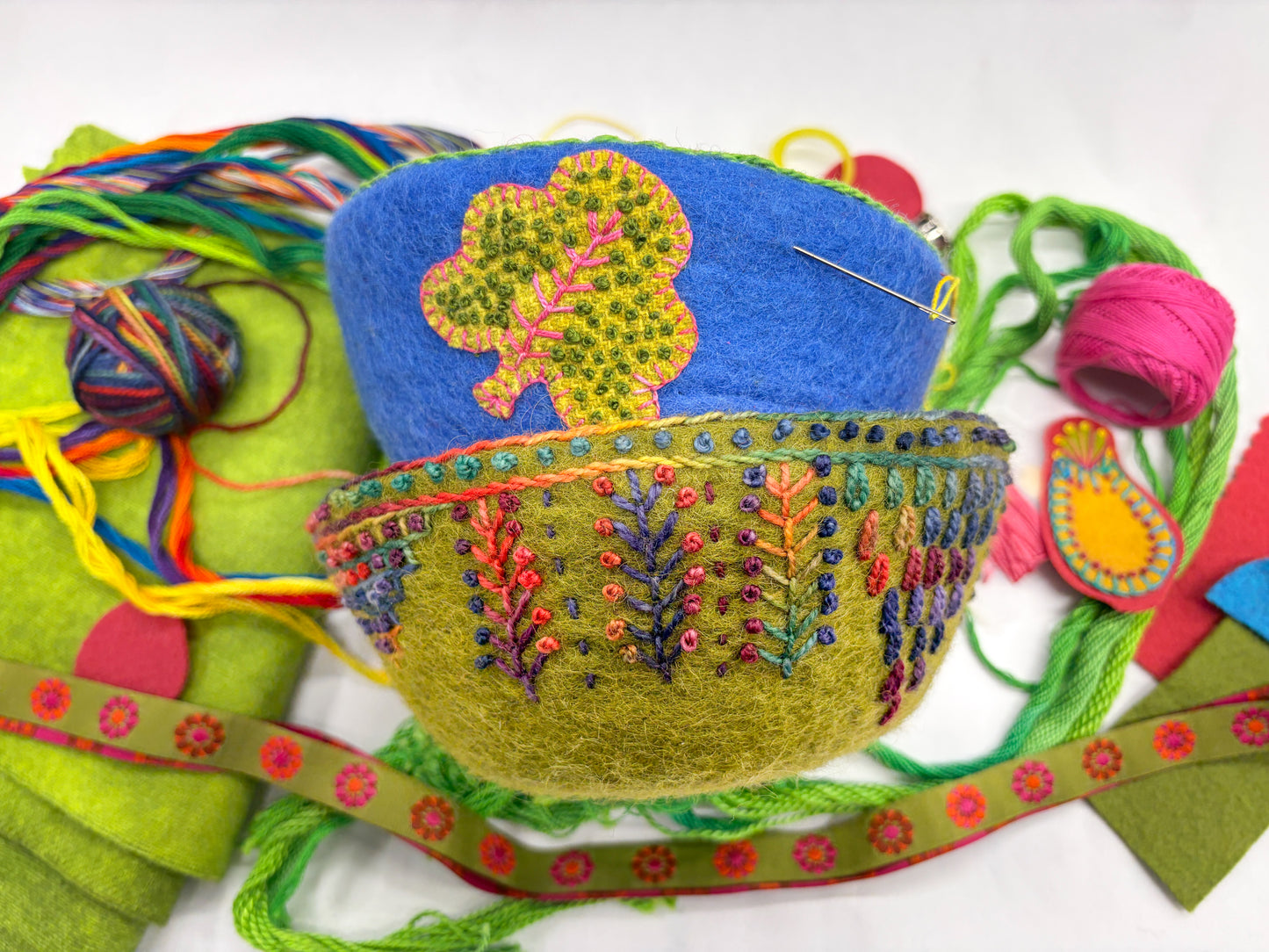 Creative Spark’s "Embroidery in the Round: Learn Stitching & Embellishment on Felt Bowls" features a vibrant felted bowl with hand-stitched embroidery and appliqué, shown with threads, felt pieces, a needle, and patterned ribbon.