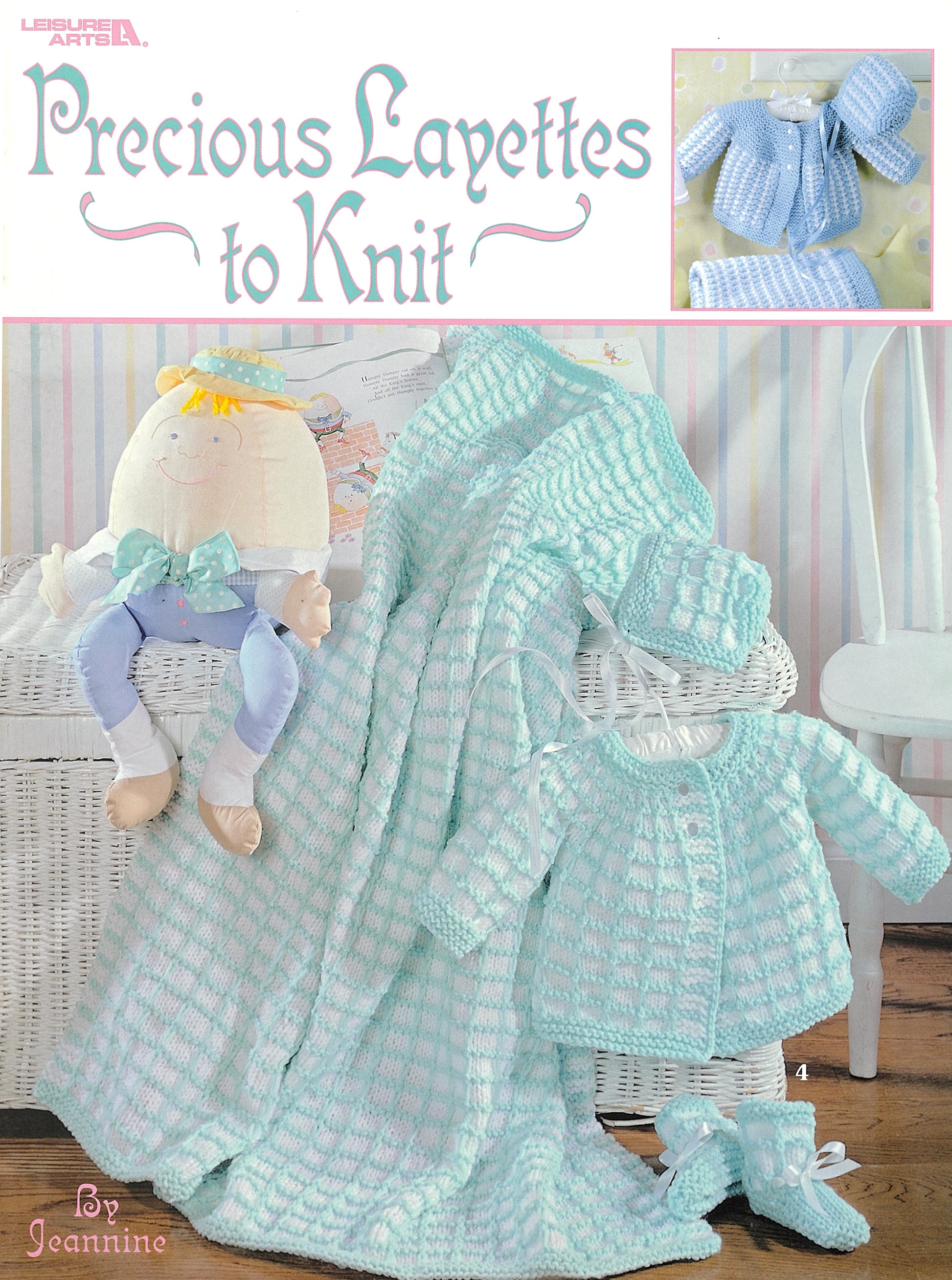 The cover of Leisure Arts' "Precious Layettes to Knit" shows pastel blue baby layette designs—including a blanket, jacket, booties, and doll—displayed in a cozy nursery setting.