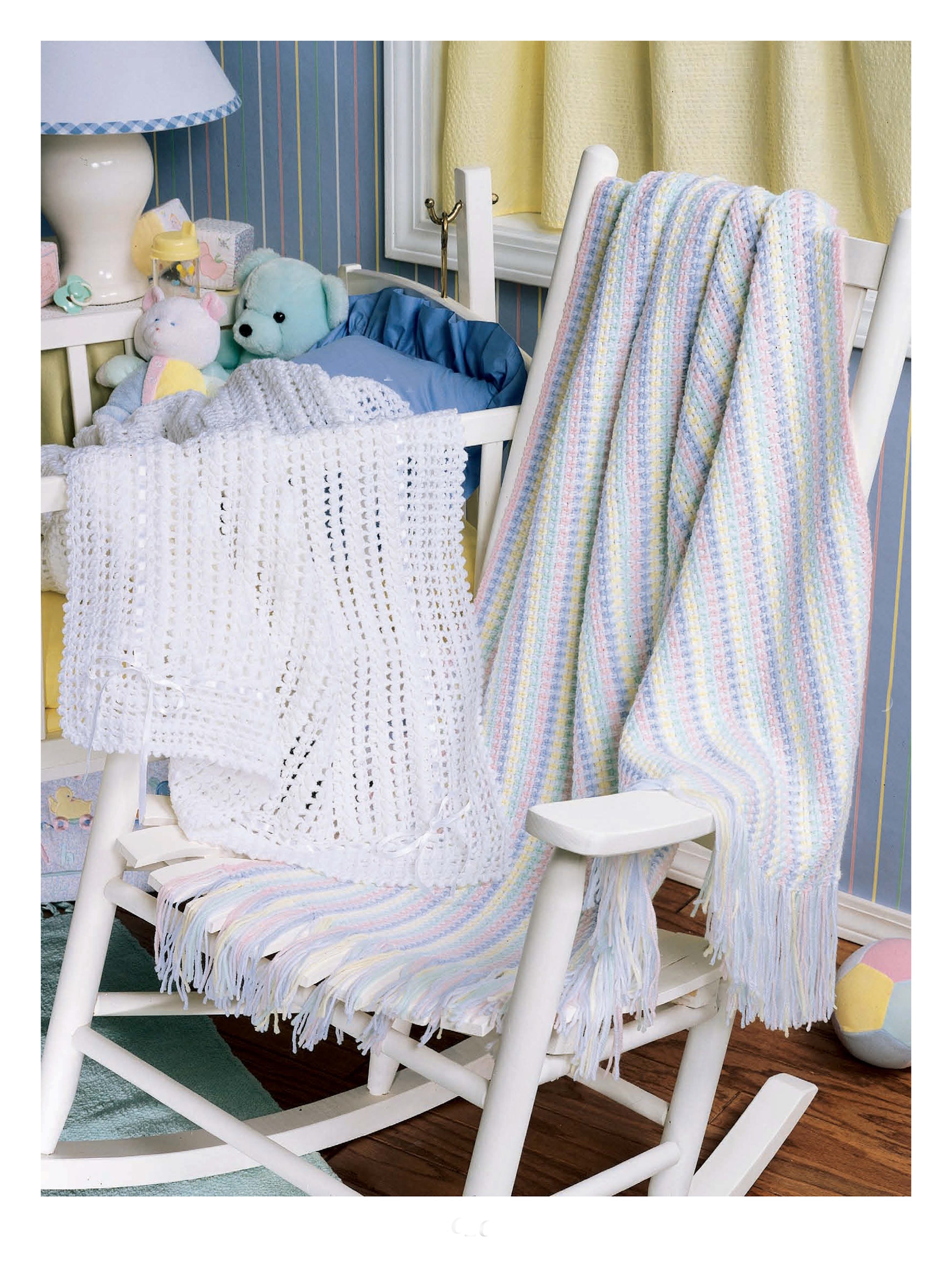 A white wooden rocking chair with soft toys in a cozy nursery displays the "Best of Terry Kimbrough Baby Afghans" by Leisure Arts, perfect for highlighting heirloom baby wraps and classic crochet designs.