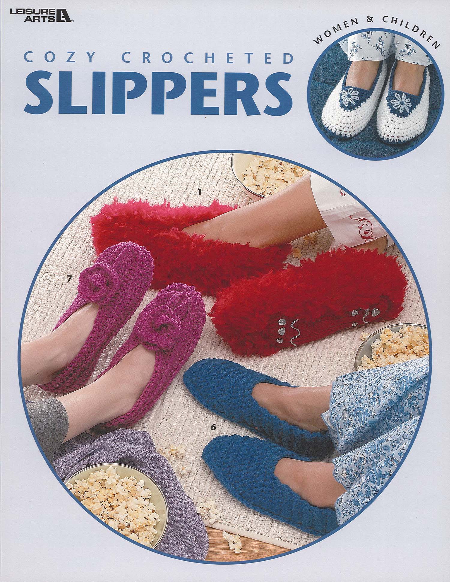 Three people in colorful, comfy slippers sit in a circle on a wooden floor with popcorn. An inset shows white crocheted slippers with a blue flower, made from worsted weight yarn. Text: “Cozy Crocheted Slippers” by Leisure Arts.