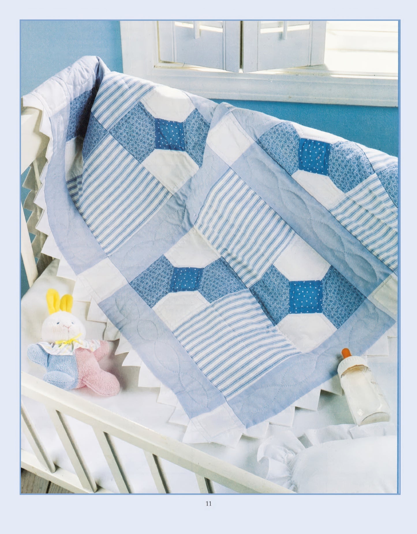 A Leisure Arts Rock-a-Bye Quilts Digital Download nursery rhyme quilt is draped over a white crib, with plush toys and a baby bottle on the mattress. Sunlight streams through the window in the background.