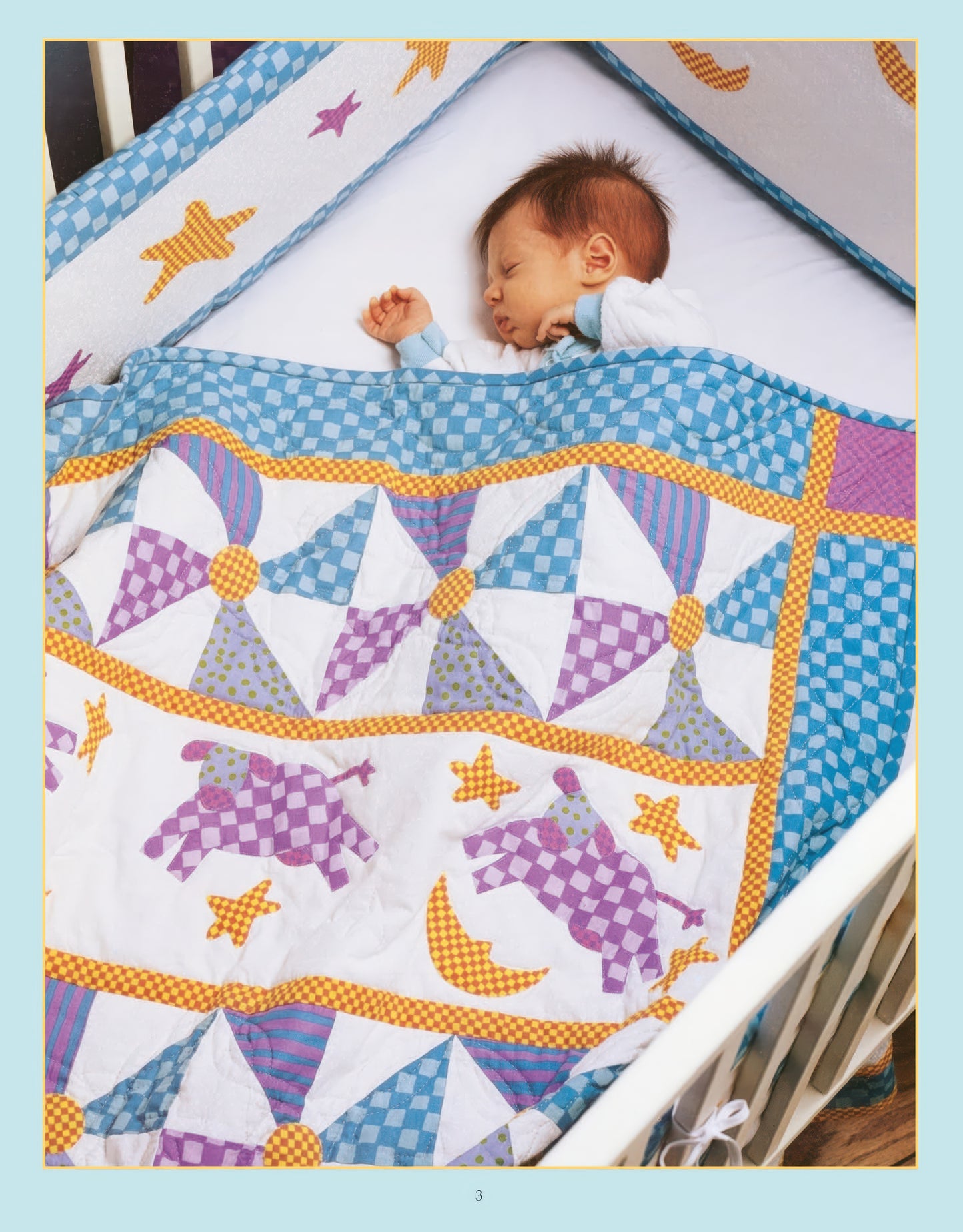A newborn sleeps in a white crib with the Rock-a-Bye Quilts Digital Download by Leisure Arts—a colorful quilt and matching bumper pads featuring blue, purple, yellow patterns with stars, moons, and clown appliqués.