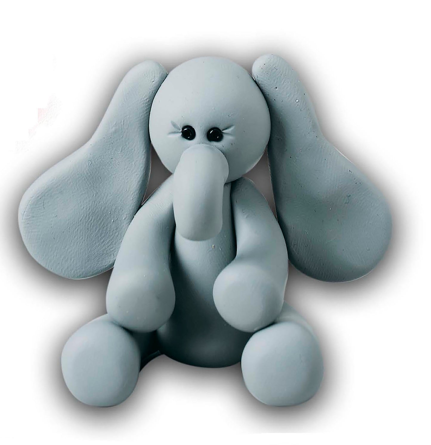 The I Can't Believe I'm Sculpting Clay Figures Digital Download by Leisure Arts features a small, light gray clay elephant with floppy ears, a long trunk, and black eyes—perfect for beginners or step-by-step sculpting inspiration.