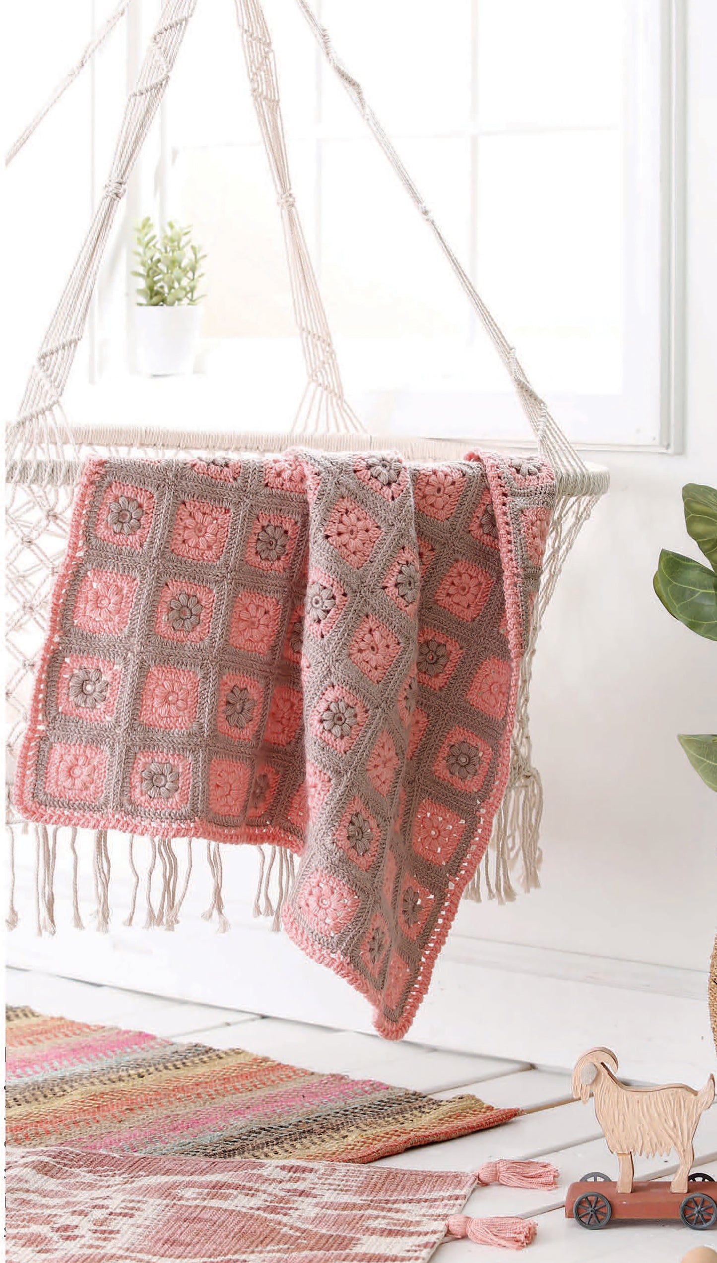 The Leisure Arts "Our Best Baby Afghans" digital download features crocheted pink and gray granny square blankets, ideal for a cozy nursery with bright decor, playful accents, and soft textures.