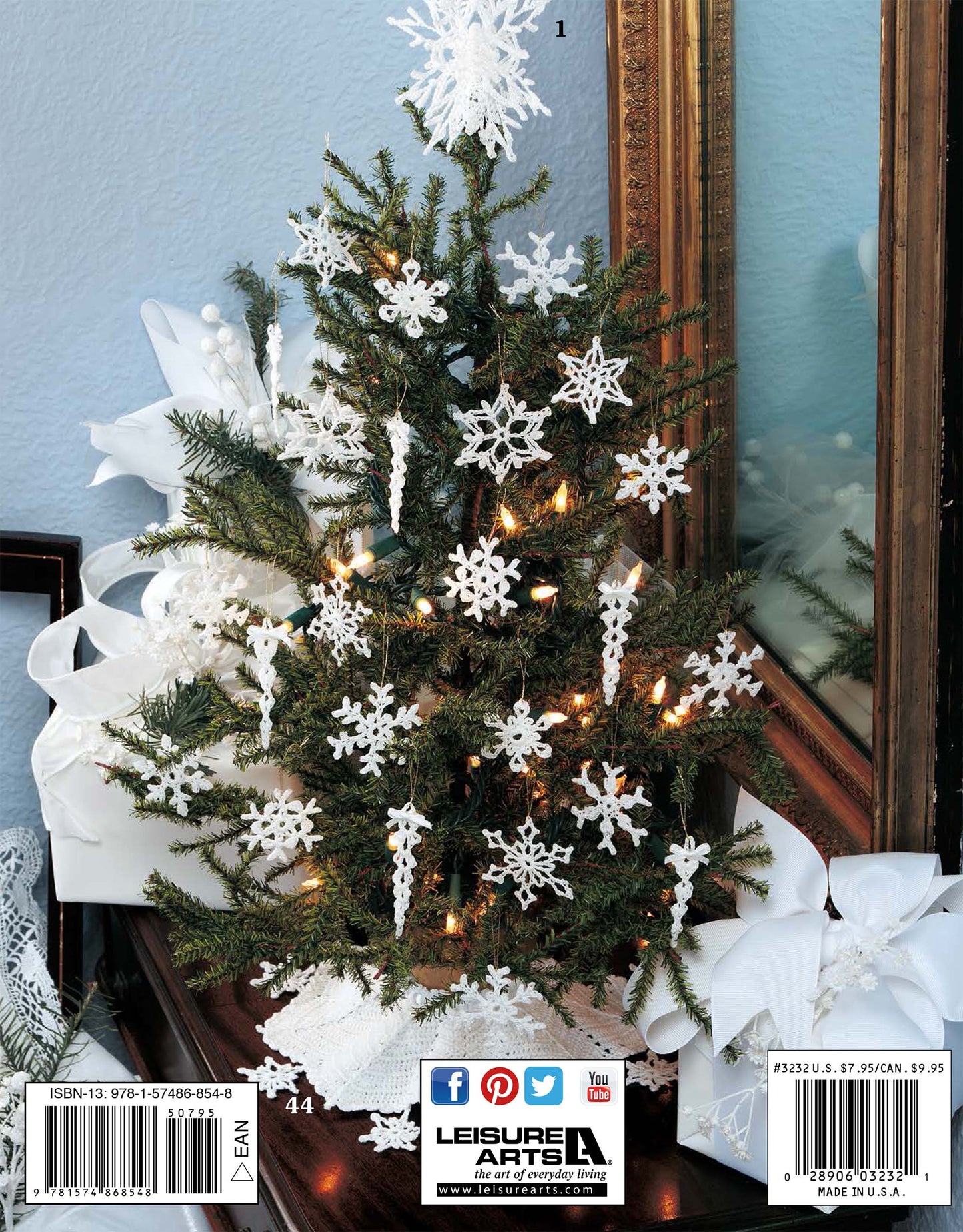 The Leisure Arts "White Christmas in Thread Crochet" digital download features elegant white crochet ornaments, perfect for decorating a small Christmas tree and creating a stylish holiday display.