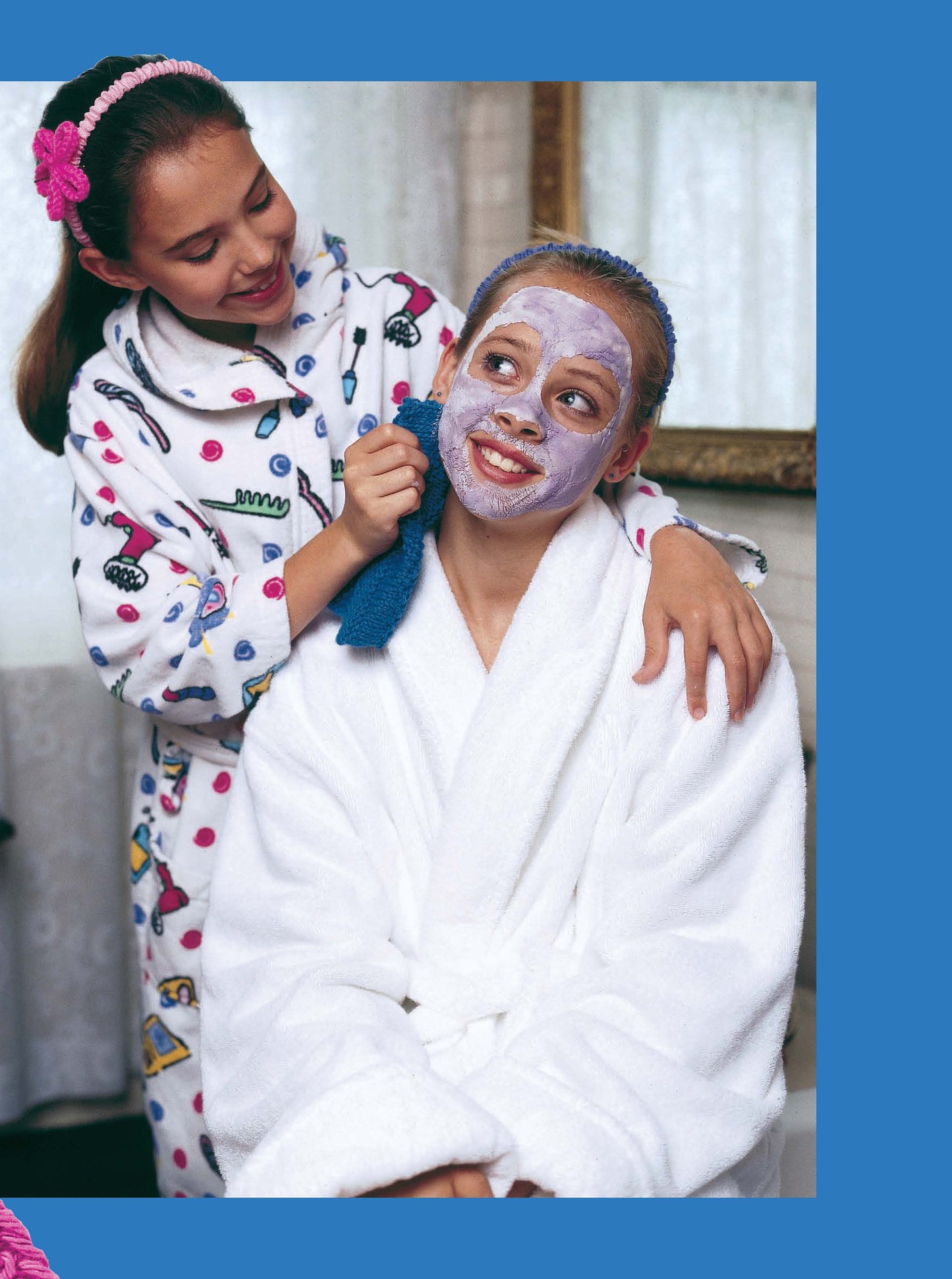 Two girls in bathrobes enjoy a spa day. One applies a face mask as they chat about their favorite knitting projects from Leisure Arts’ Cool Stuff for Kids Teach Me to Knit—12 Projects Digital Download, perfect for kids and teens.