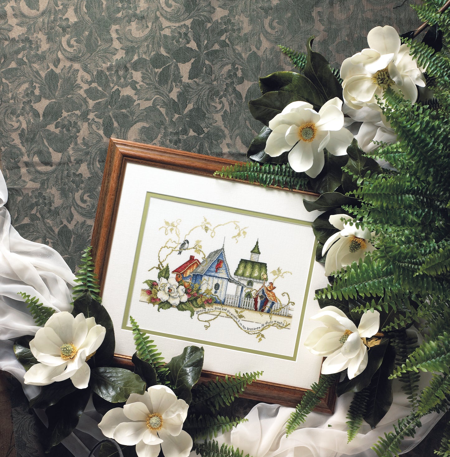The Unity Birdhouses Cross Stitch Digital Download by Leisure Arts features charming birdhouses and floral motifs, beautifully arranged with greenery on a patterned backdrop for a delightful, craft-ready design.