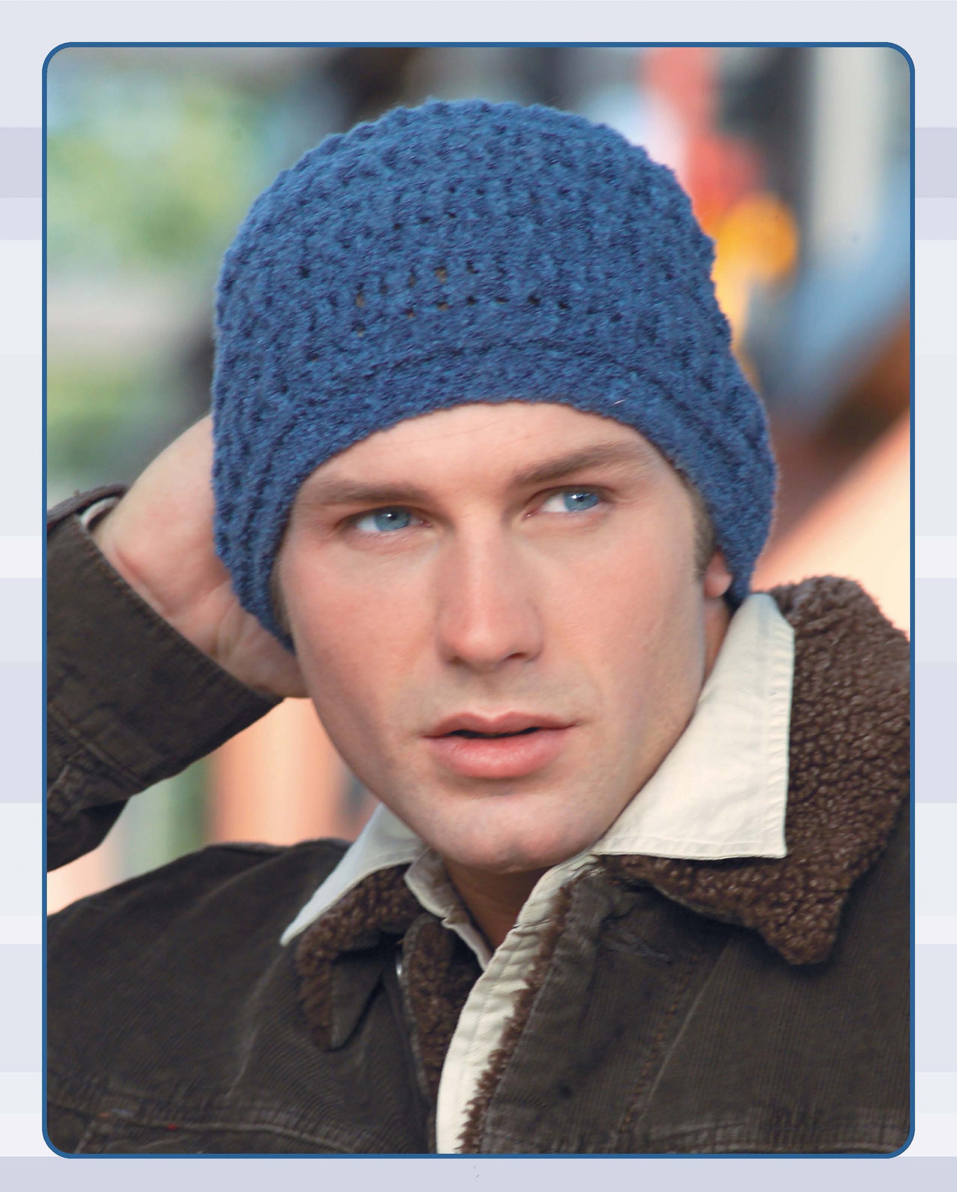 A man in a blue knit beanie from Leisure Arts' Quick Caps—7 Crochet Designs and a brown shearling-collar jacket looks to the side, holding one hand to his head.