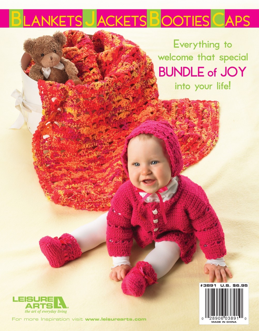 A smiling baby in a pink crochet outfit sits on a yellow blanket beside a basket with a teddy bear. Text promotes "Bright Layettes to Crochet" by Leisure Arts—patterns for baby blankets, jackets, booties, and caps using sport yarn.