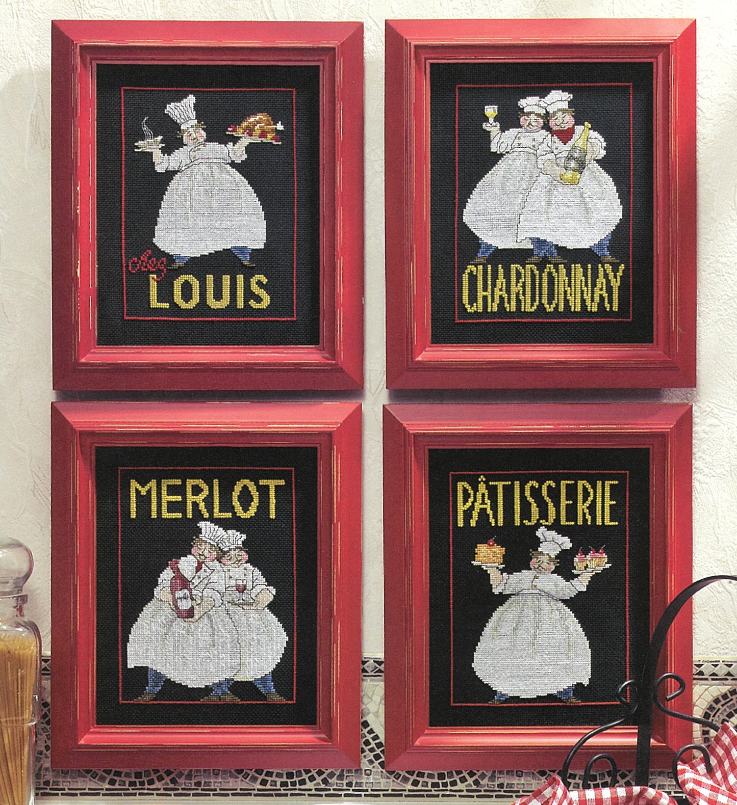 Leisure Arts’ “French Chefs—4 Cross Stitch Designs” features chefs with French-themed words—CHARDONNAY, MERLOT, PÂTISSERIE, and chez LOUIS—each holding food or drink. Framed in red, these designs make stylish kitchen decor.