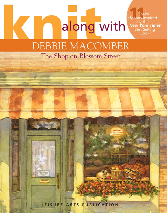 Book cover for Knit Along with Debbie Macomber—The Shop on Blossom Street by Leisure Arts, featuring an illustrated storefront with a green door, flowers, and yarn. Orange and white text overlays the design—ideal for baby afghan enthusiasts.