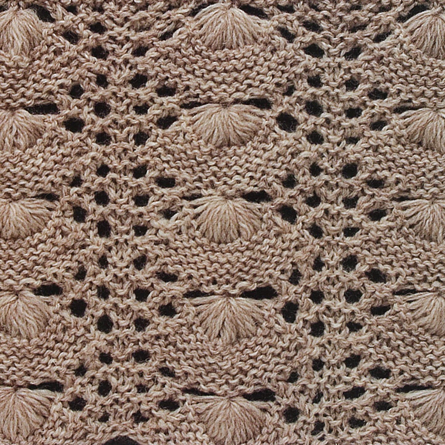 Close-up of a beige knit from Leisure Arts’ "50 Fabulous Knit Stitches," featuring textured shell-like motifs and openwork lace—a stunning example for beginner knitting enthusiasts exploring new stitch patterns.