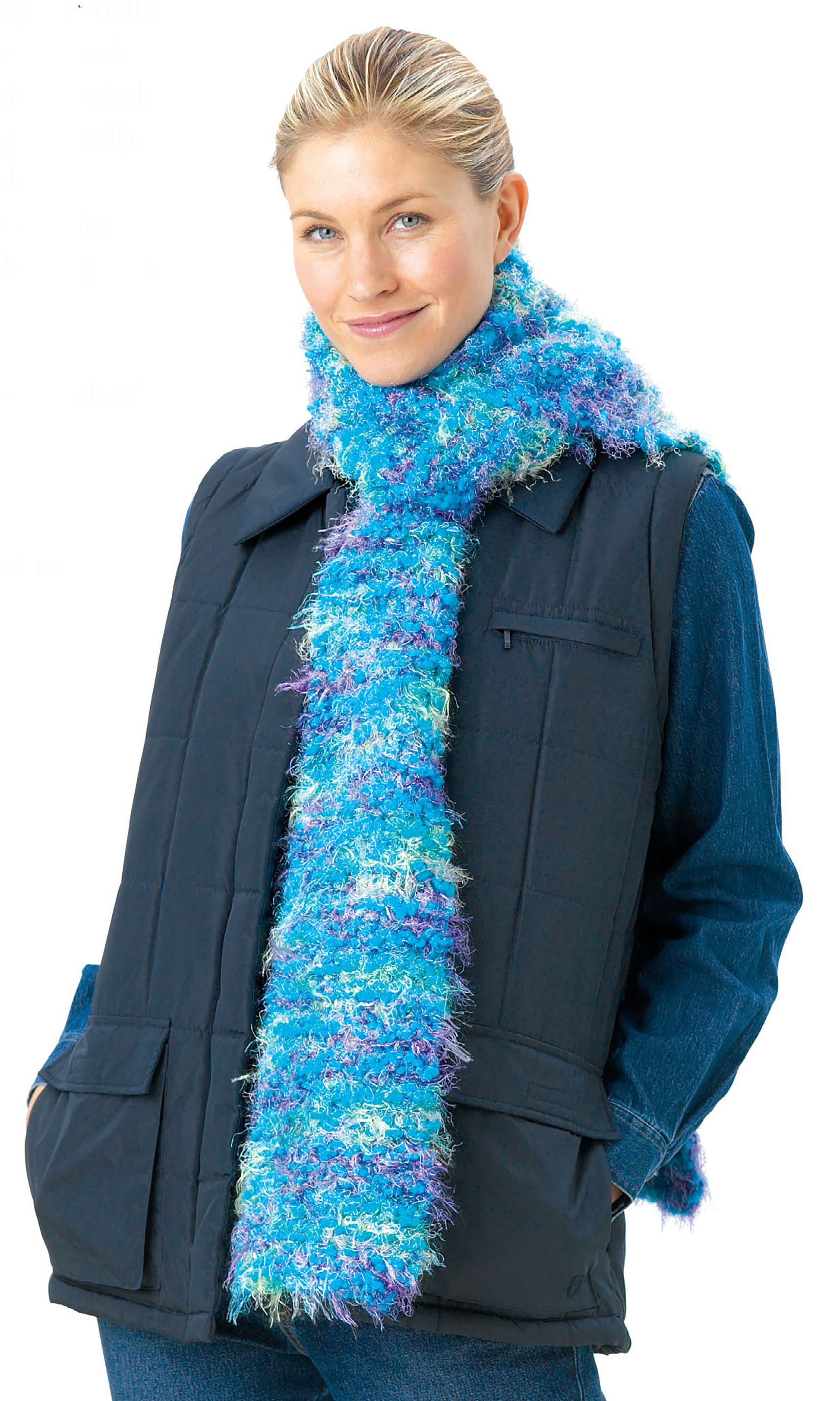 A smiling person in a dark vest and blue denim shirt wears a fluffy blue and purple scarf—ideal for craft projects from the Big Book of Knit Hats & Scarves for Everyone by Leisure Arts—wrapped around their neck against a plain white background.