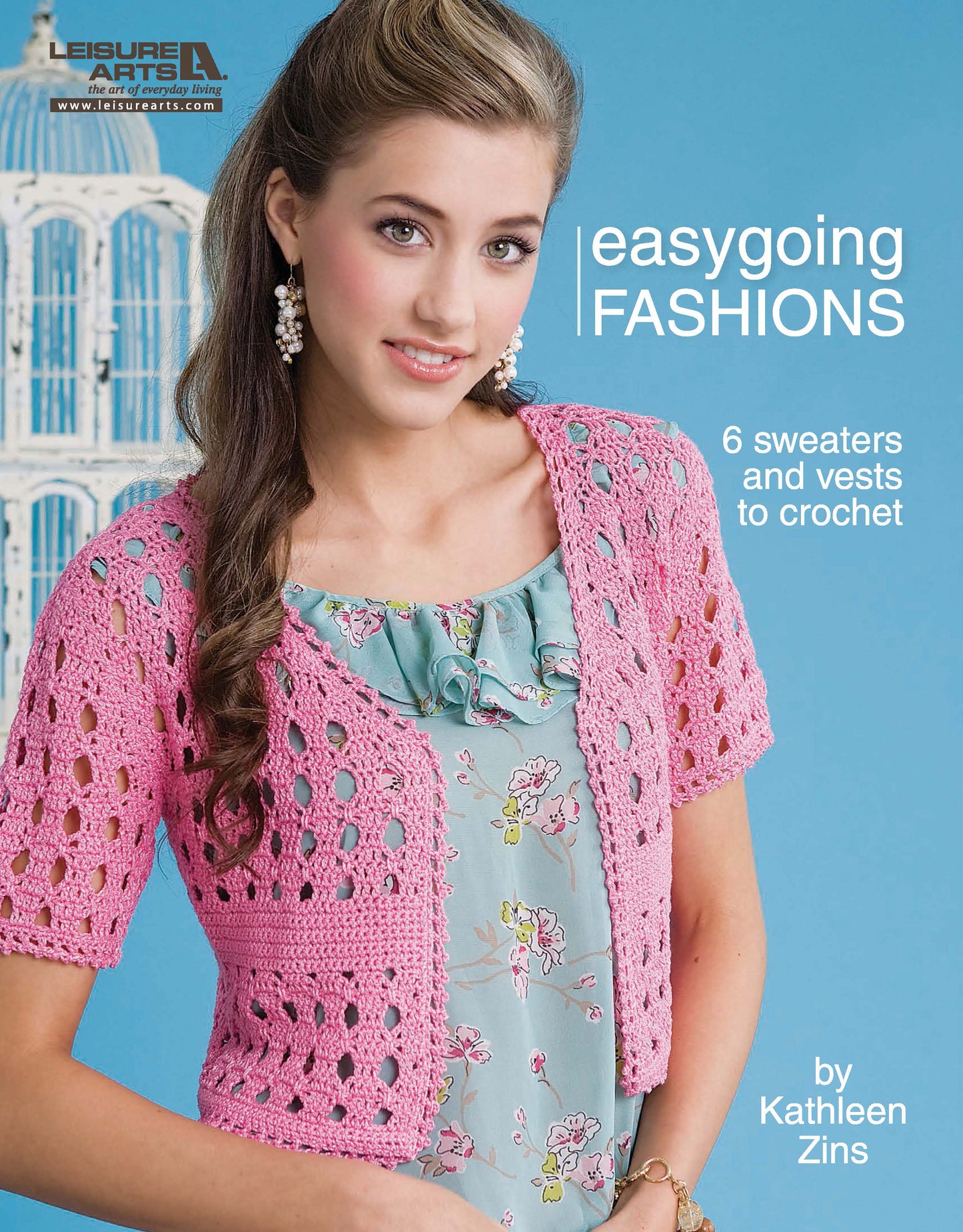 A woman smiles in a pink crocheted cardigan over a floral dress. Text: Crochet Easygoing Fashions by Leisure Arts—6 patterns for cropped sweaters and vests.