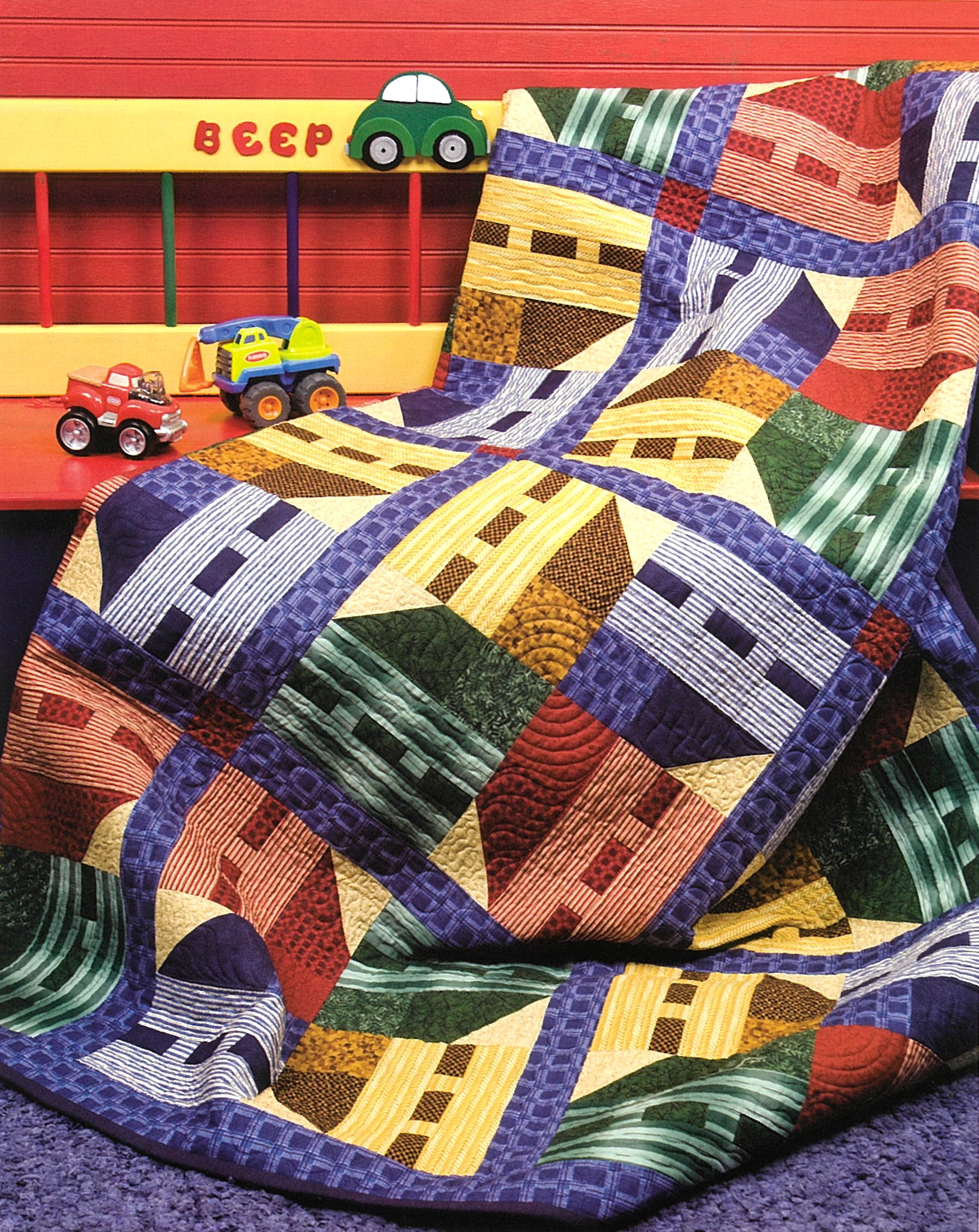A playful quilt from Debbie Mumm's Cuddle Quilts For Little Girls and Boys by Leisure Arts, featuring house patterns, hangs on a crib rail. Toy cars sit nearby and "BEEP" is painted above on a vivid red wall.