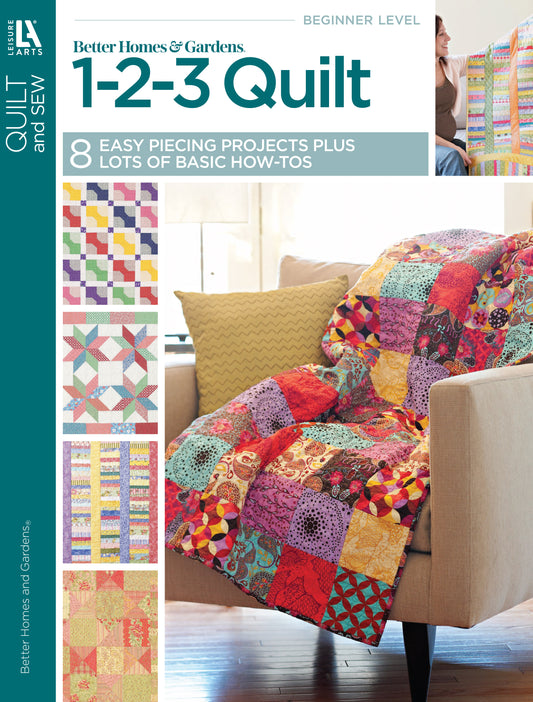 A vibrant patchwork quilt drapes over a yellow chair with pillows, beside simple quilt patterns. The cover reads: Better Homes and Gardens 1-2-3 Quilt by Leisure Arts—8 easy projects plus basic how-tos for beginner quilting.