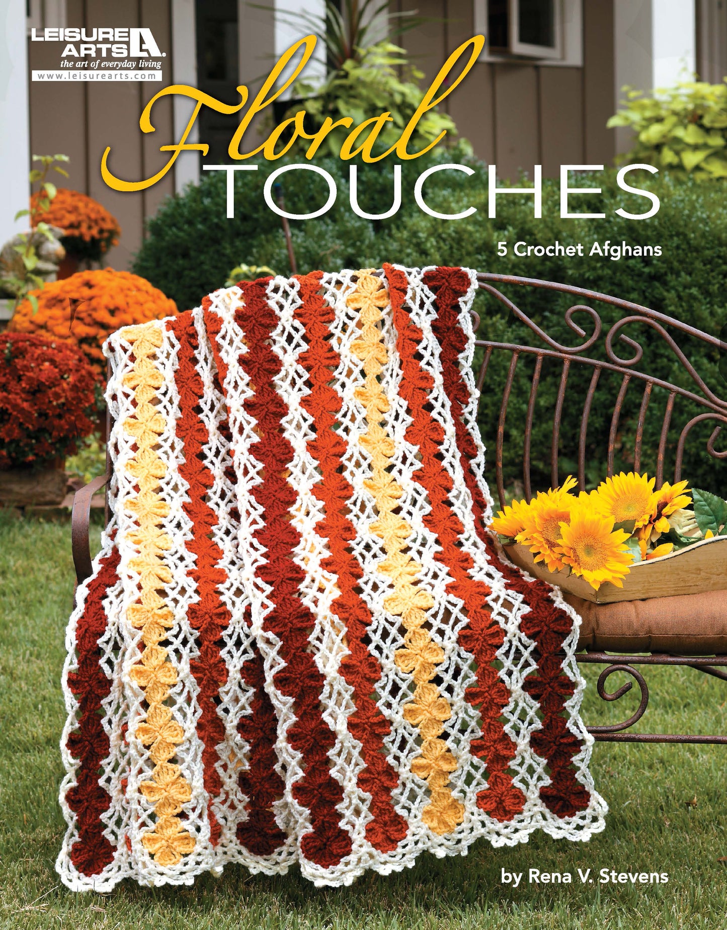A metal bench in a garden with orange and yellow flowers is draped with a red, yellow, and white crocheted afghan. Text: "Floral Touches Digital Download by Leisure Arts.
