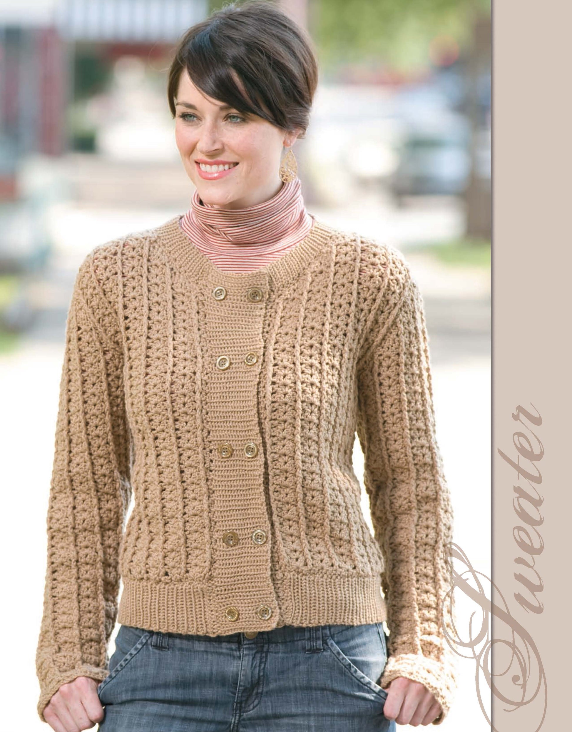 A woman outdoors wears a tan, textured, button-up sweater from The Crochet Closet by Leisure Arts over a striped turtleneck. She smiles with her hands in jean pockets. "Sweater" is written vertically on the right side.