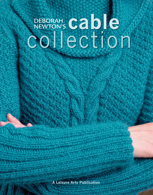 A person in a teal cable-knit cowl neck sweater, arms folded. Features women’s sweaters and classic knitting designs from Deborah Newton's Cable Collection by Leisure Arts.