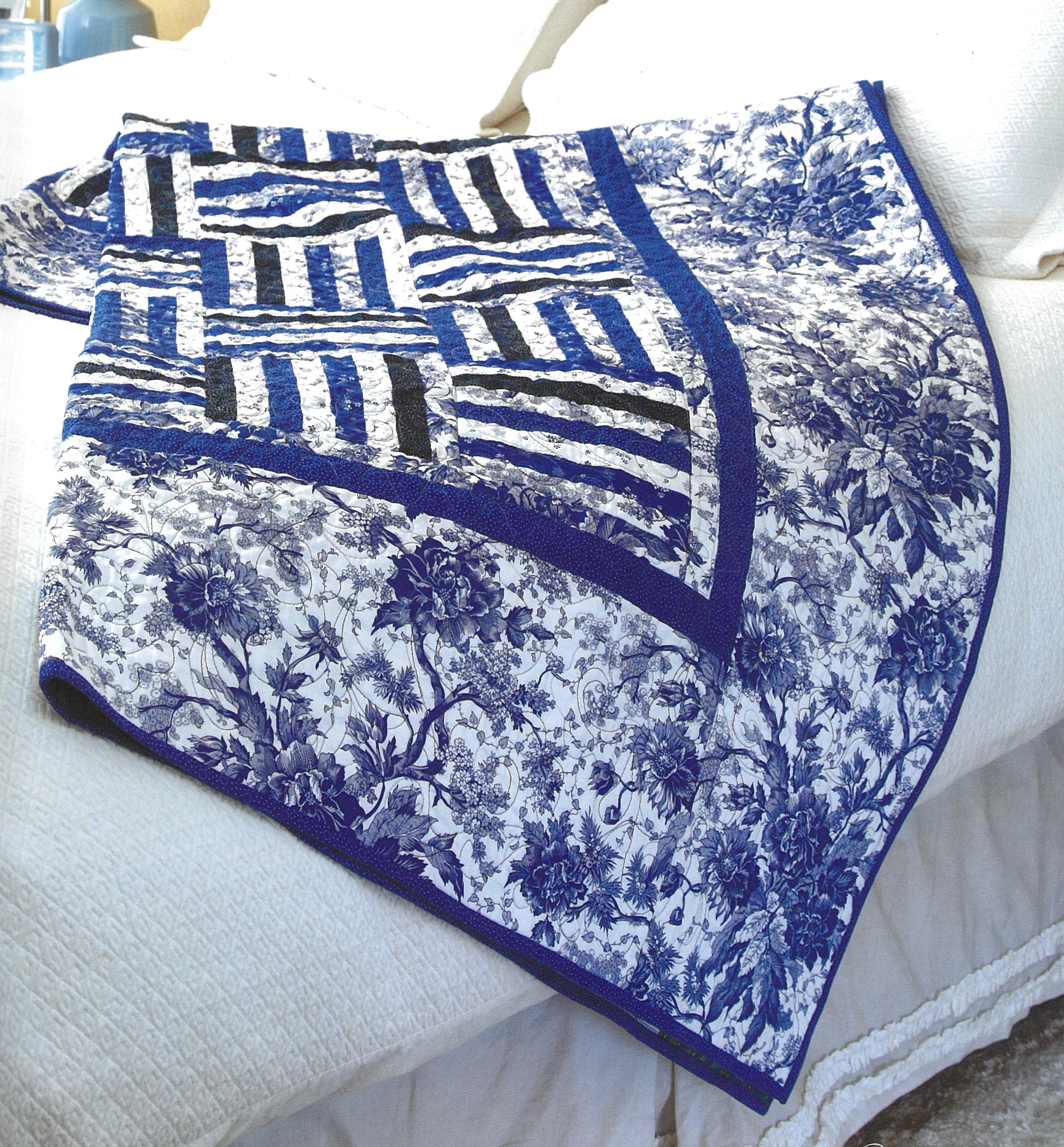 Pat Sloan's Camera, Color, Quilts! by Leisure Arts features a blue and white quilt with floral and geometric patterns—perfect inspiration for your next quilting project. The design uses coordinated charm packs in various shades of blue.