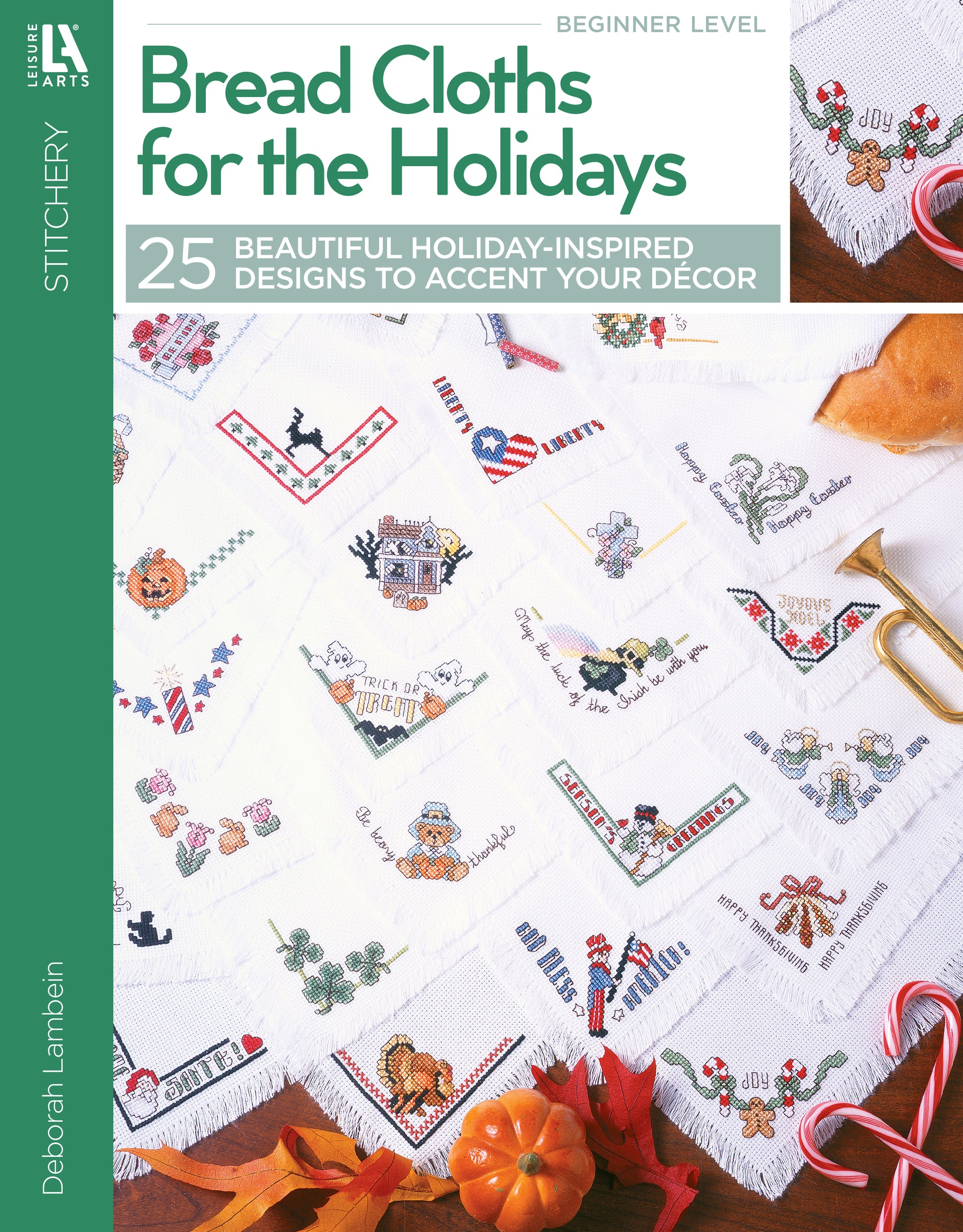 The image shows the cover of Leisure Arts’ "Bread Cloths for the Holidays," featuring white holiday towels with colorful embroidery, festive decorations, ribbon, holly, and gold scissors.