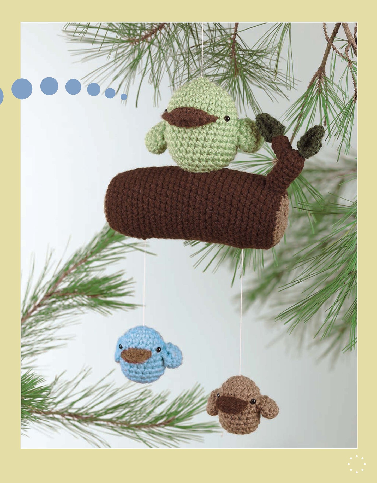 More Cute Little Animals To Crochet" by Leisure Arts offers a charming green bird on a brown log mobile with two smaller birds, perfect for beginners seeking unique amigurumi crochet patterns.