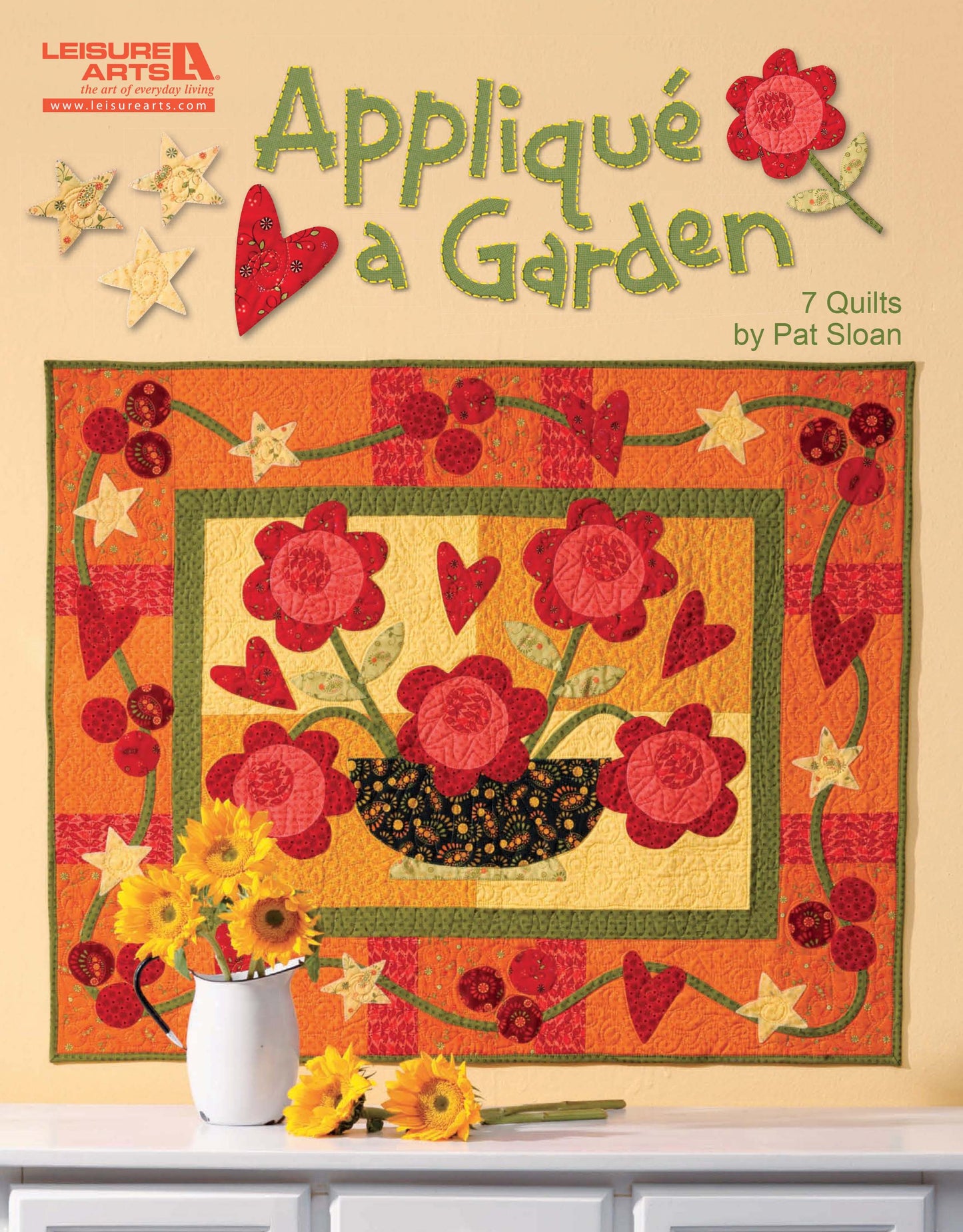 Leisure Arts' "Appliqué a Garden" book features colorful quilt designs with red flowers, hearts, and swirls—ideal for wall hangings or table runners. A vase of yellow flowers is shown below. Author: Pat Sloan.