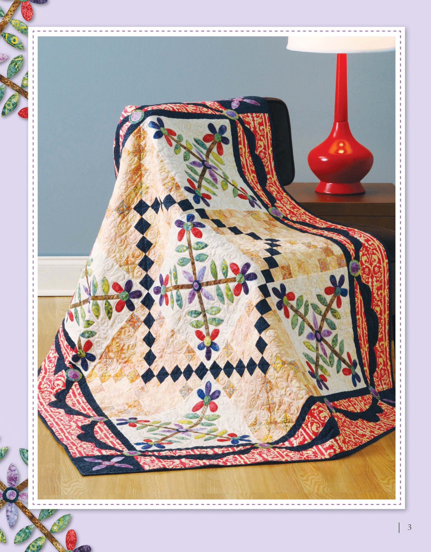 The “Appliqué a Garden” quilt by Leisure Arts, featuring floral and geometric patterns, is draped over a dark wooden table beside a red lamp, set against a gray wall and light wood floor—ideal for applique or table runner projects.