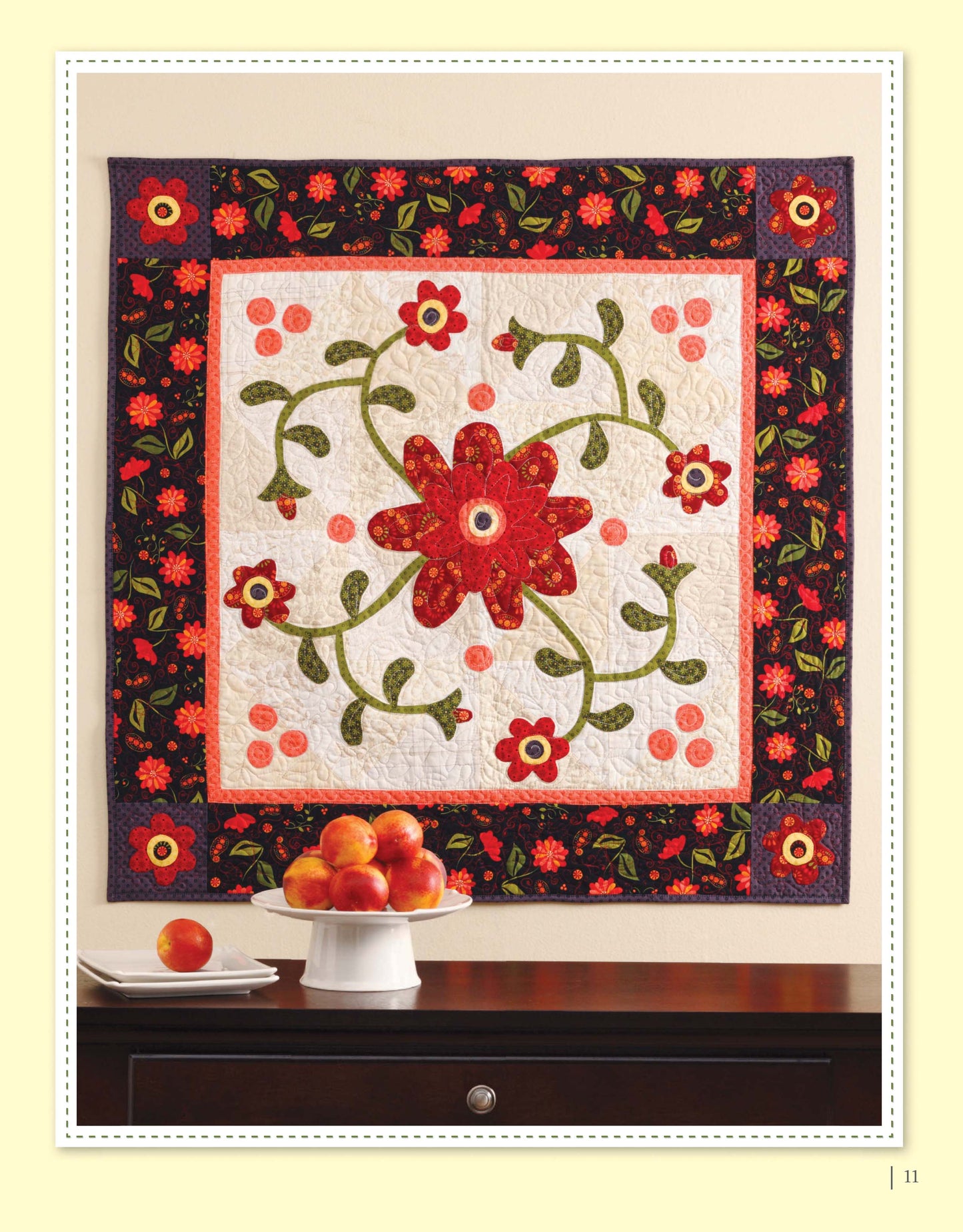 Appliqué a Garden" by Leisure Arts is a decorative quilt ideal for wall hangings or appliqué projects, featuring a central flower and leafy vines in red, orange, and green above a table with a bowl of peaches.
