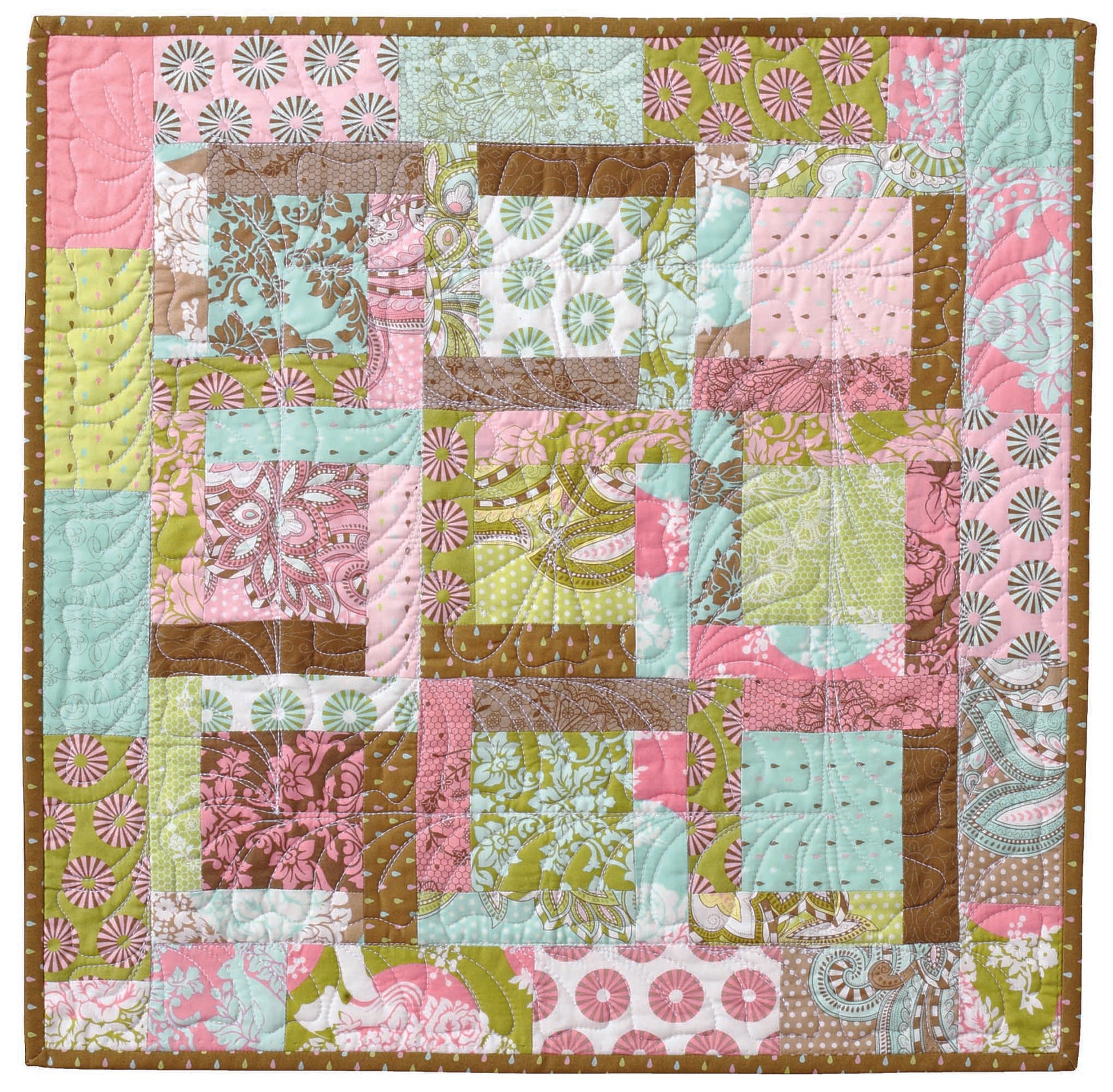 The Three Times the Charm Quilt Projects Digital Download by Leisure Arts features pastel and patterned square patchwork in pink, green, blue, white, and brown with a brown polka dot border—ideal for baby shower gifts or quick quilting projects.