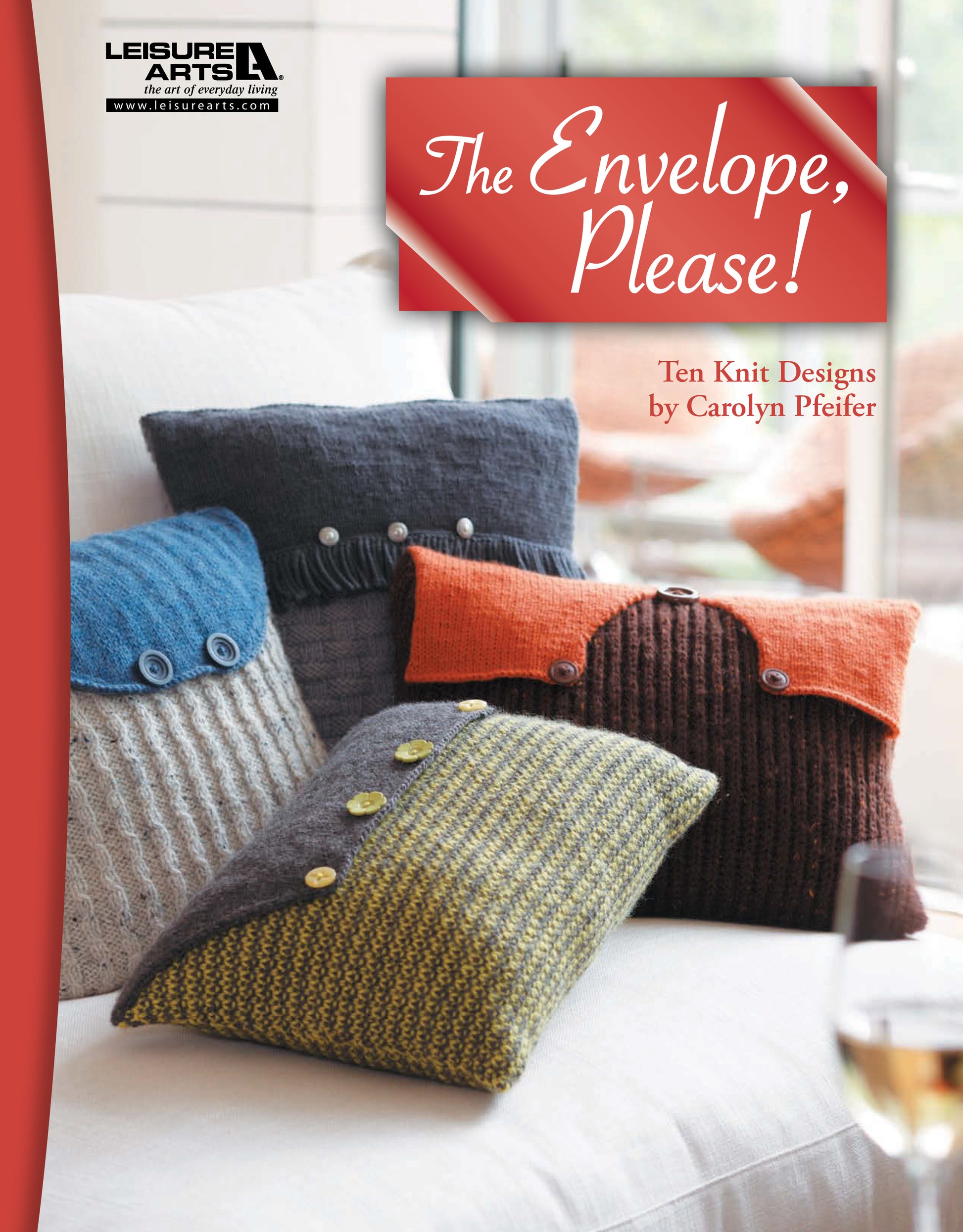 Four colorful knit pillow covers with buttoned envelope flaps are displayed on a white couch. Above them is The Envelope, Please!—Ten Knit Designs Digital Download from Leisure Arts, featuring patterns for knitted pillows.