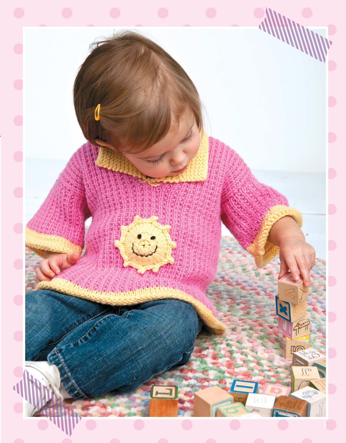 A toddler in a bright, mix-and-match sweater with a sun motif sits on a rug, playing with letter blocks. Framed in pink polka dots and tape, this is the perfect inspiration for children’s knits from "Pick the Pieces Knitting" by Leisure Arts.
