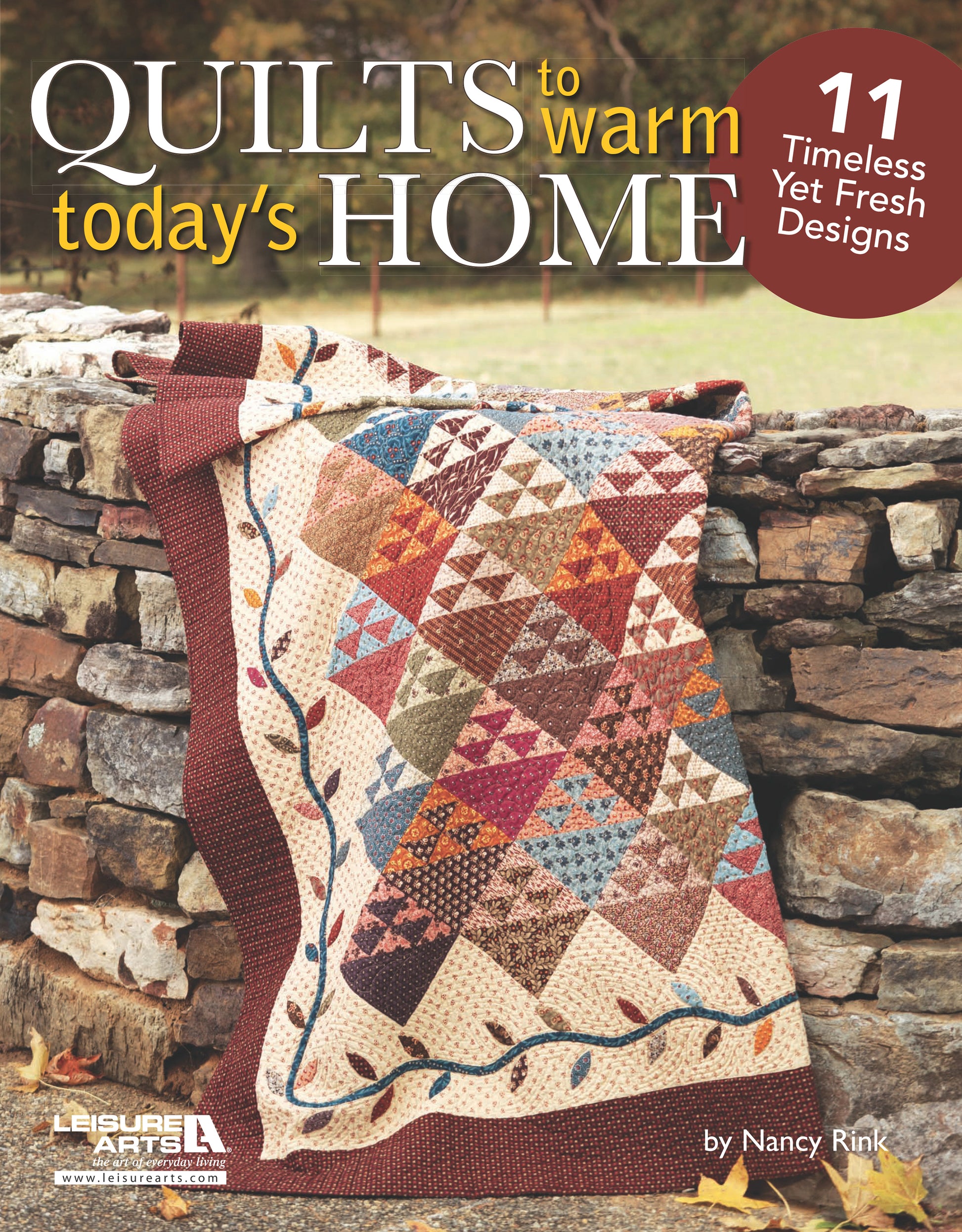 A colorful patchwork quilt with red, blue, and cream diamonds is draped over a stone wall. Overlaid text features “Quilts to Warm Today's Home Digital Download” by Leisure Arts, offering 11 homestyle quilt projects and patterns.