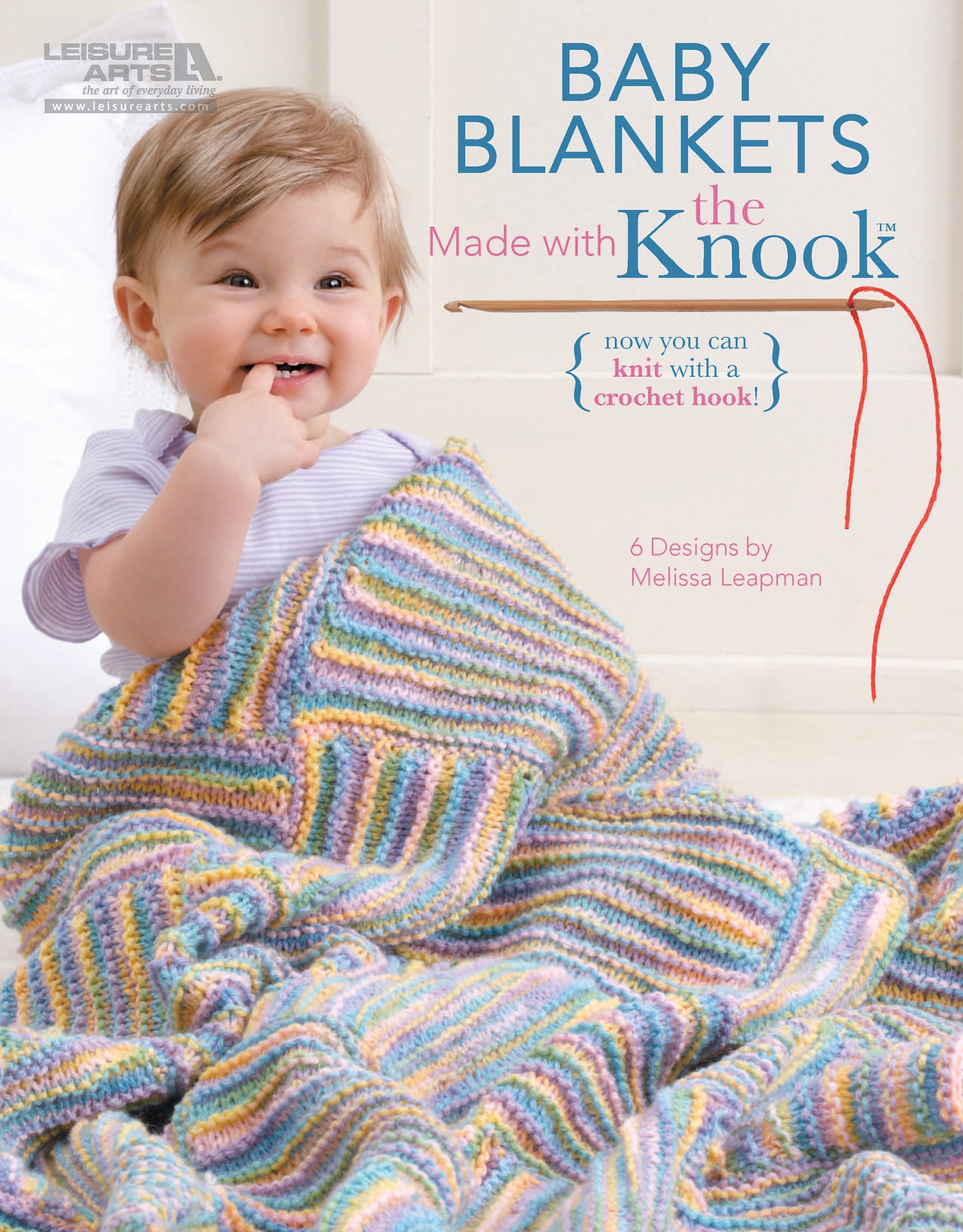 A happy baby sits wrapped in a striped knitted blanket, holding it while chewing on their fingers. The cover reads "Baby Blankets Made with the Knook" by Leisure Arts, featuring six cozy patterns by Melissa Leapman.