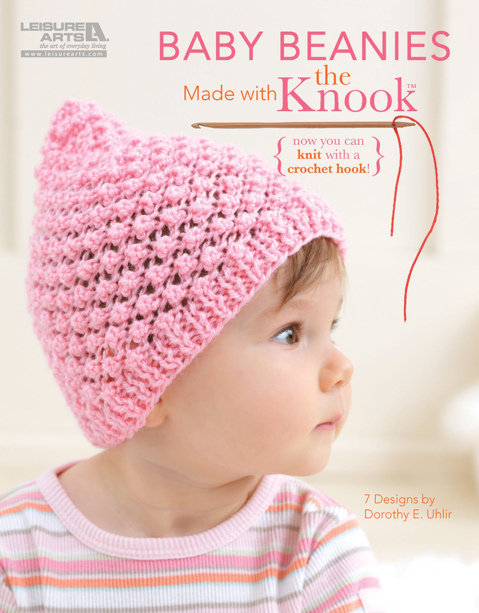 A baby wearing a pink beanie looks to the side. Text: Baby Beanies Made with the Knook by Leisure Arts—7 cute designs in soft, knitted styles you can crochet easily with the Knook tool. Designs by Dorothy E. Uhlir.