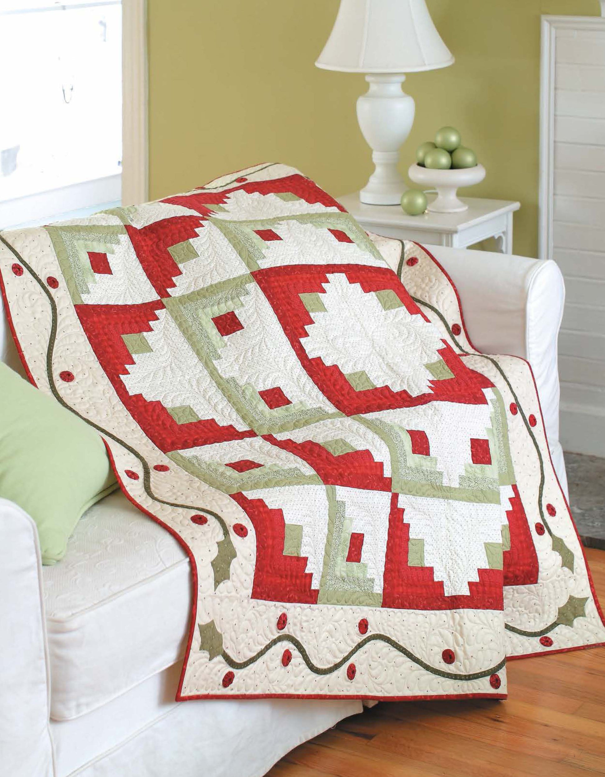 The Christmas Sparkle—7 Whimsical Embellishments That Truly Sparkle! by Leisure Arts adds festive charm to a cozy living room, beautifully complementing a red, white, and green geometric quilt and holiday decor accents.
