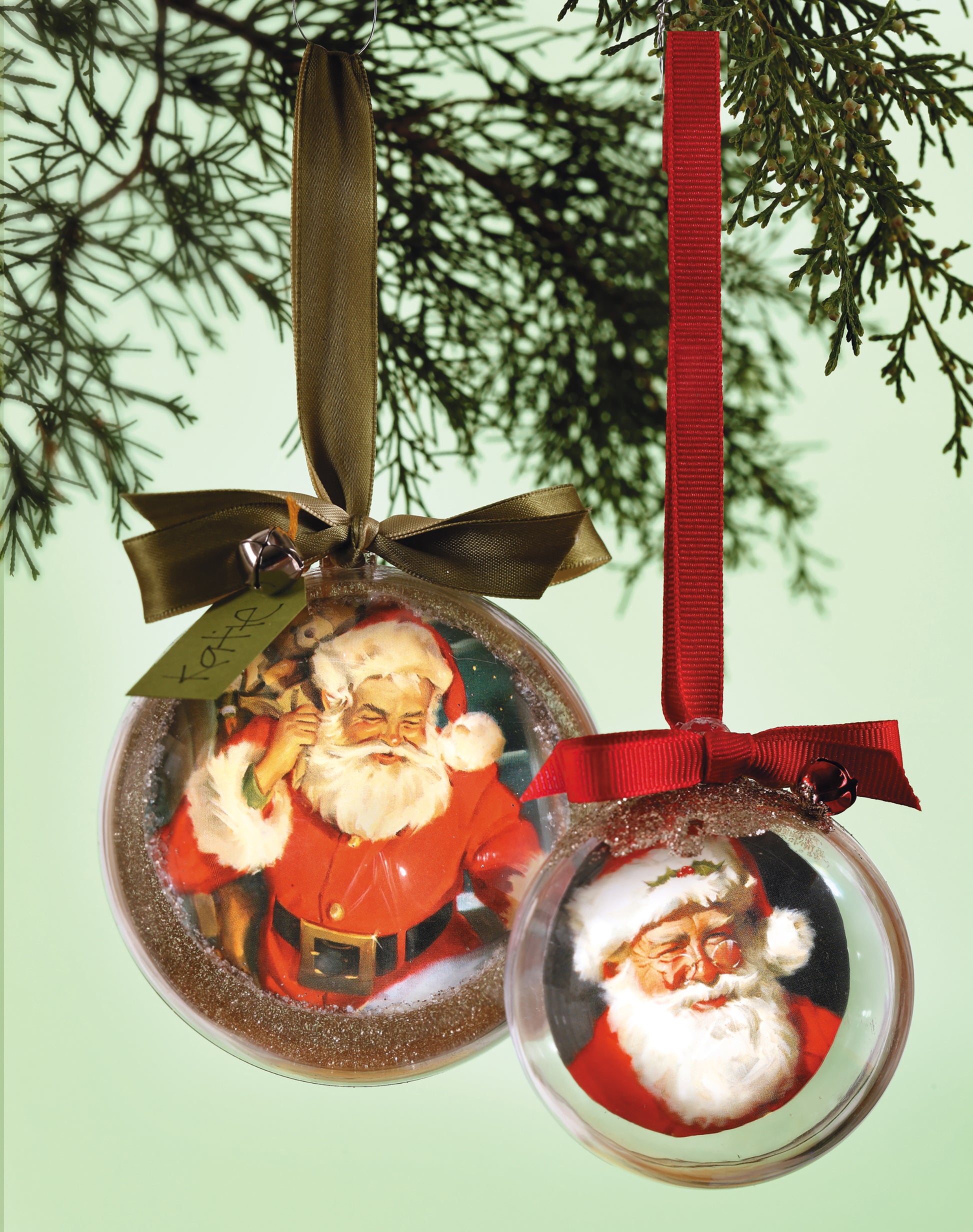 The Holiday Ornaments Digital Download by Leisure Arts features two easy-to-craft Christmas ornaments with vintage Santa images: the larger ornament has a gold ribbon bow, and the smaller one a red ribbon bow—perfect for hanging on your tree.