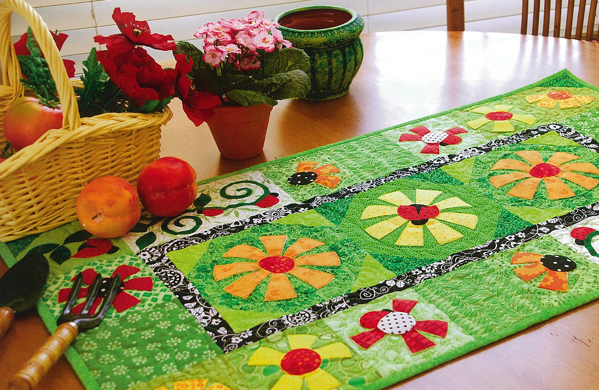 The Leisure Arts Fresh & Fun Applique—12 Projects features a colorful quilted table runner with bright flower patterns, perfect for year-round beauty on your table or in any garden-inspired space.