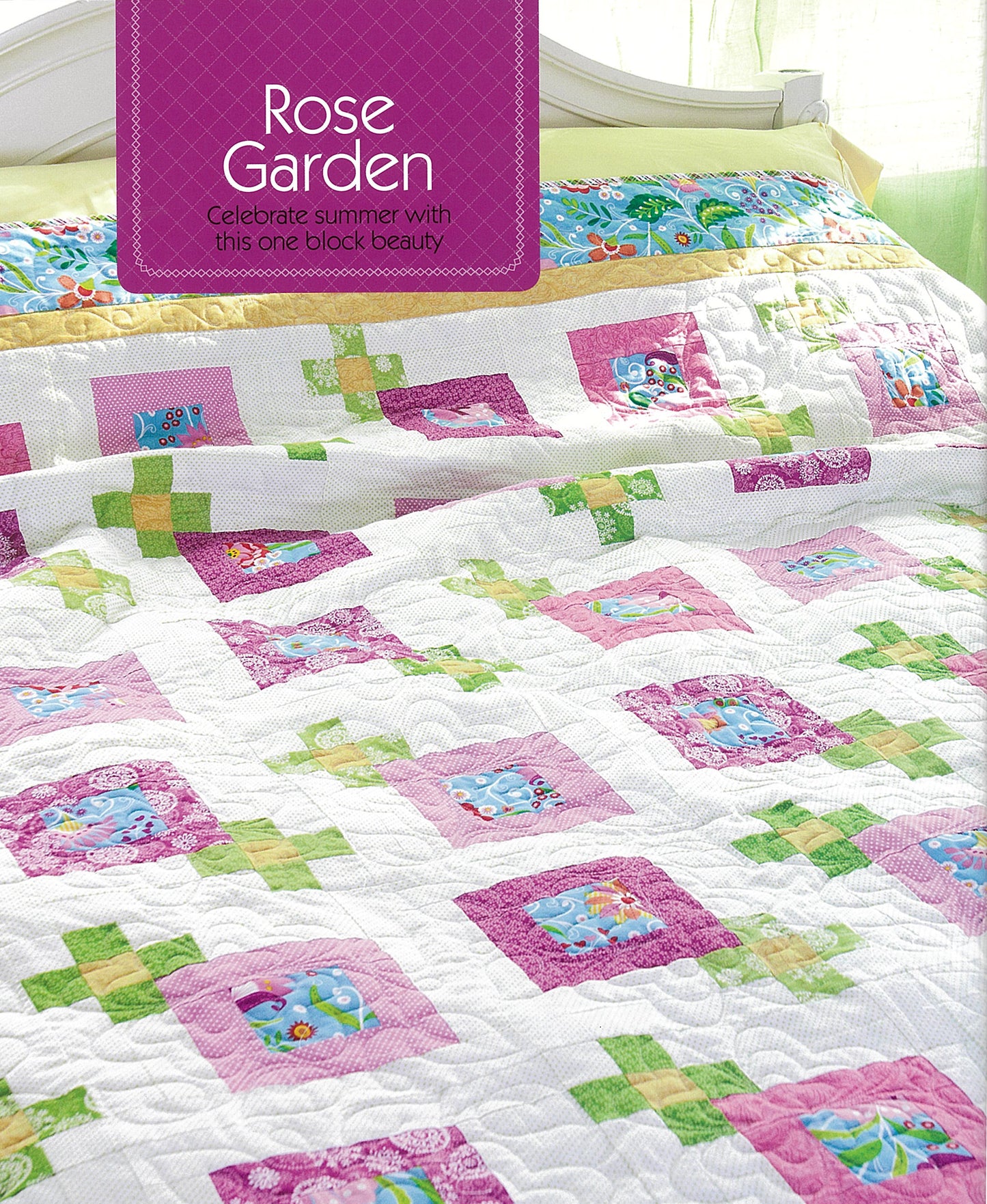 A bed is covered with a pink, white, yellow, and green quilt made from Simple Patchwork Quilts—Best of Quiltmaker by Leisure Arts. Above it hangs a "Rose Garden" sign as sunlight filters through green curtains.