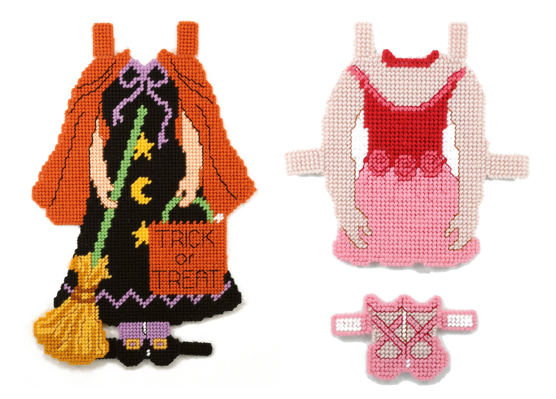 The Leisure Arts Paper Dolls set includes two cross-stitched outfits: a witch costume with broom and treat bag, and a pink ballerina dress with a matching bodice accessory.
