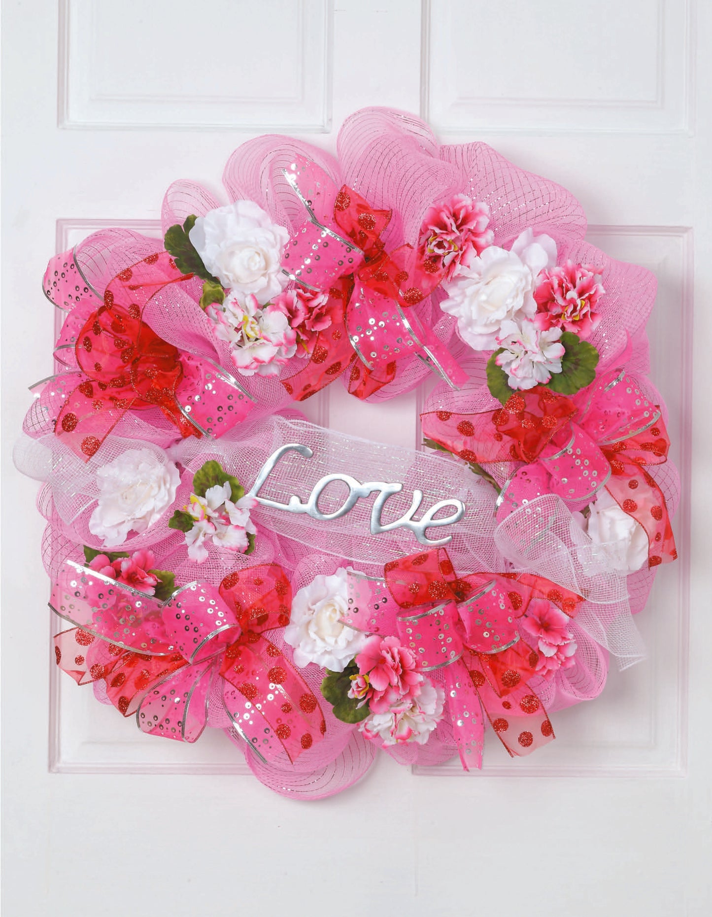 Learn to Make Deco Mesh Wreaths by Leisure Arts helps you craft colorful pink and red wreaths with flowers, ribbons, and a white Love sign—ideal for decorating your entryway or enhancing your wreath making skills.