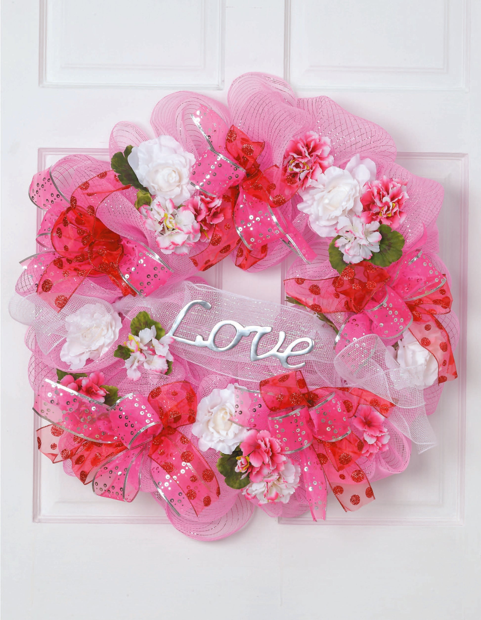 Learn to Make Deco Mesh Wreaths by Leisure Arts helps you craft colorful pink and red wreaths with flowers, ribbons, and a white Love sign—ideal for decorating your entryway or enhancing your wreath making skills.