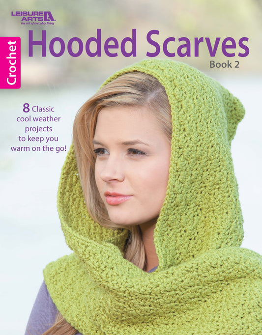 A woman wears a textured light green crocheted hooded scarf. The Leisure Arts Hooded Scarves, Book 2 Digital Download features eight easy crochet projects and classic scarf patterns for cool weather.