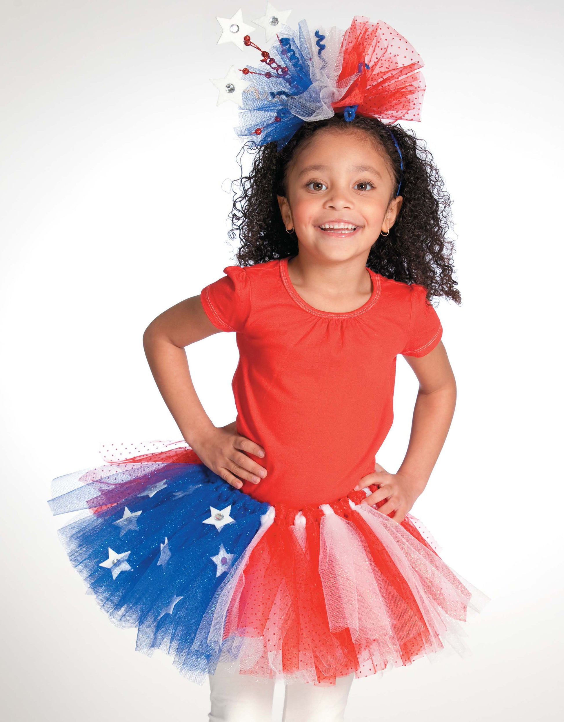 Smiling young girl models "A Tutu for Every Occasion" by Leisure Arts, wearing a patriotic red top, star-spangled no sew tutu, and matching headband—perfect to showcase beginner tutu designs against a white background.