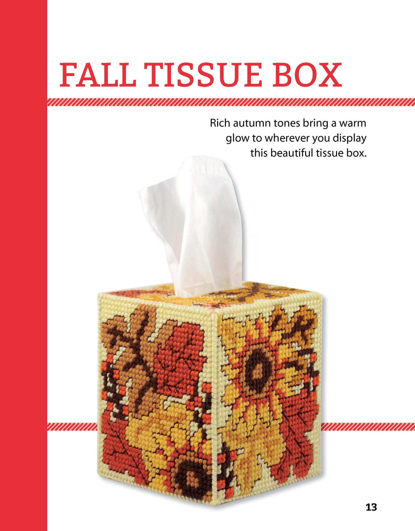 A square tissue box cover from Leisure Arts’ Tissue Boxes & Coasters Digital Download features a plastic canvas cross-stitched autumn floral design in red, orange, and yellow. A white tissue pulls from the top. Text reads FALL TISSUE BOX.