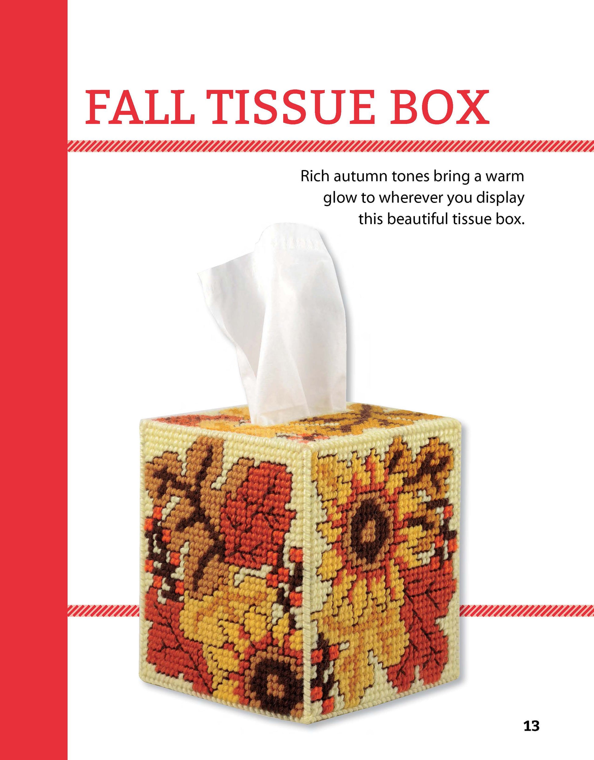 A square tissue box cover from Leisure Arts’ Tissue Boxes & Coasters Digital Download features a plastic canvas cross-stitched autumn floral design in red, orange, and yellow. A white tissue pulls from the top. Text reads FALL TISSUE BOX.