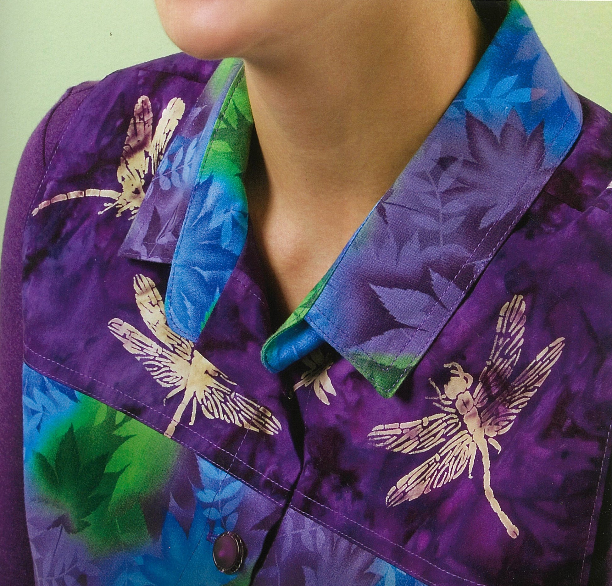A person wears a vibrant leafy shirt with beige dragonflies, inspired by Sew Basics & Beyond: Simple Embellishments from Leisure Arts—ideal for fashion projects or stylish home techniques.